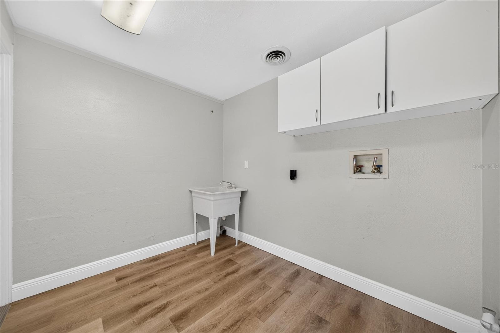 Interior laundry room with utility sink and cabinets. - 1448 CUMBIE ST, ORLANDO