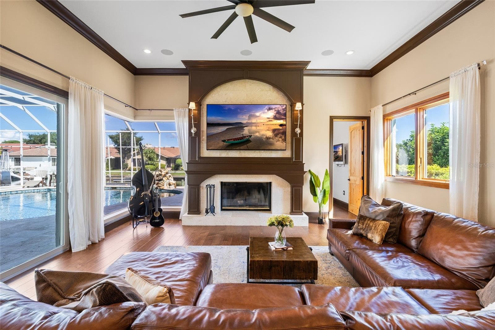 Family room with sliders to pool area, mitered glass window, and wood burning fireplace - 9805 COMPASS POINT WAY, TAMPA