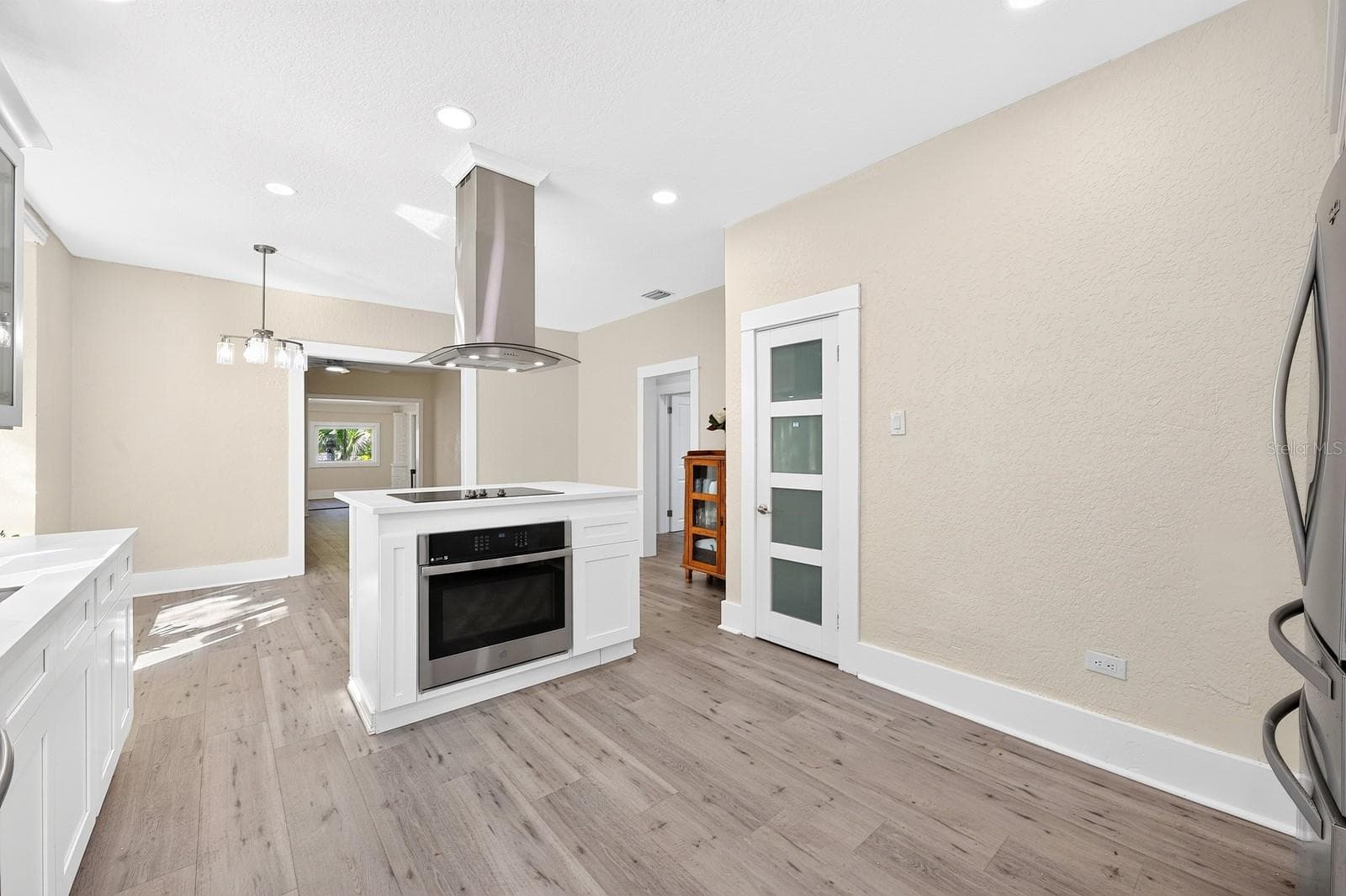 The center island boasts a built-in oven, cooktop and a curved glass range hood. - 211 S MAPLE AVE, SANFORD