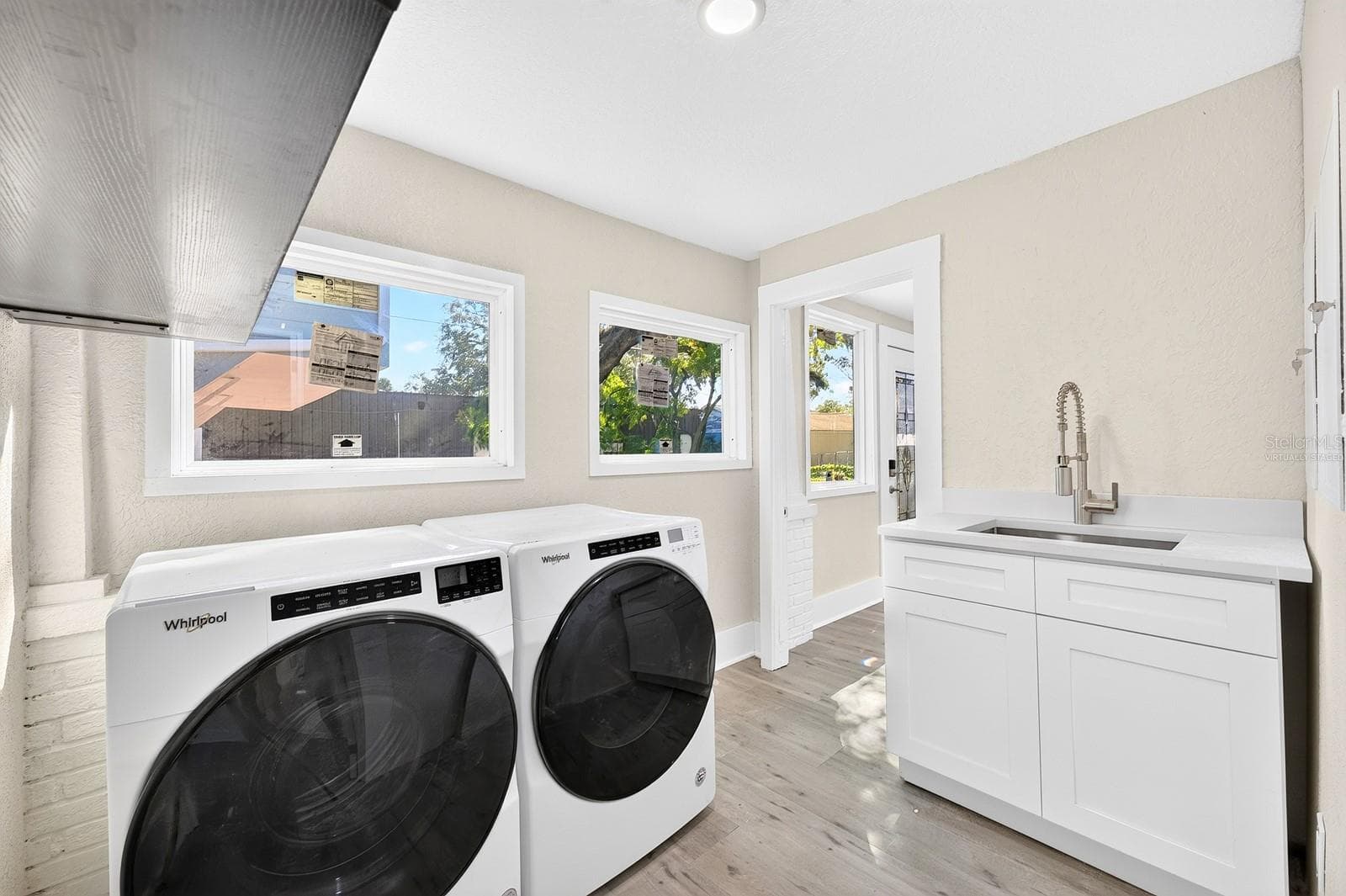 The dedicated Laundry Room includes the washer and dryer, along with EXTRA STORAGE and a vanity with sink. - 211 S MAPLE AVE, SANFORD
