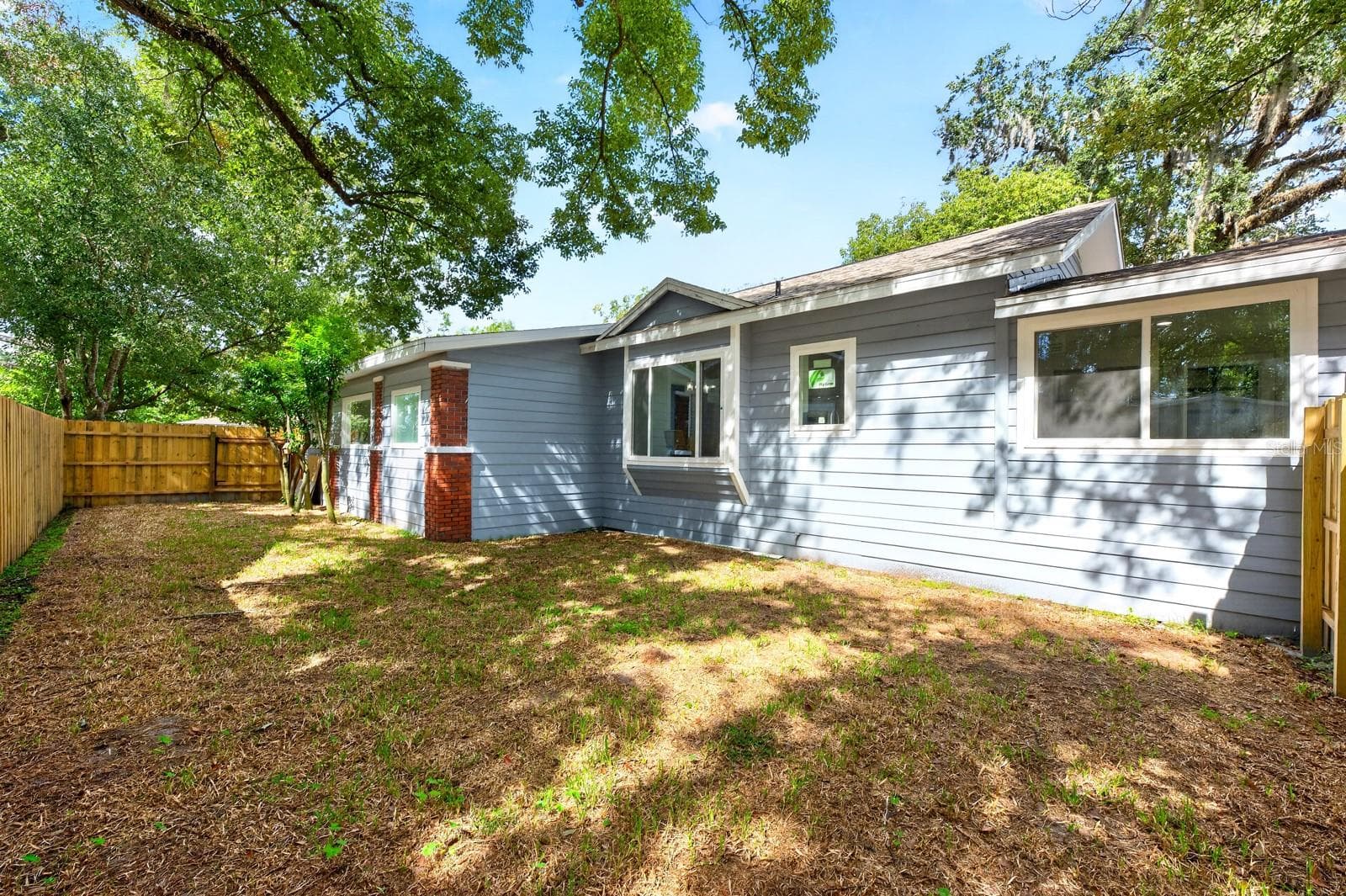 Outside, MATURE TREES AND STATELY OAKS lend natural beauty and a sense of established character to the grounds, while the FENCED BACKYARD offers room to enjoy the outdoors. - 211 S MAPLE AVE, SANFORD
