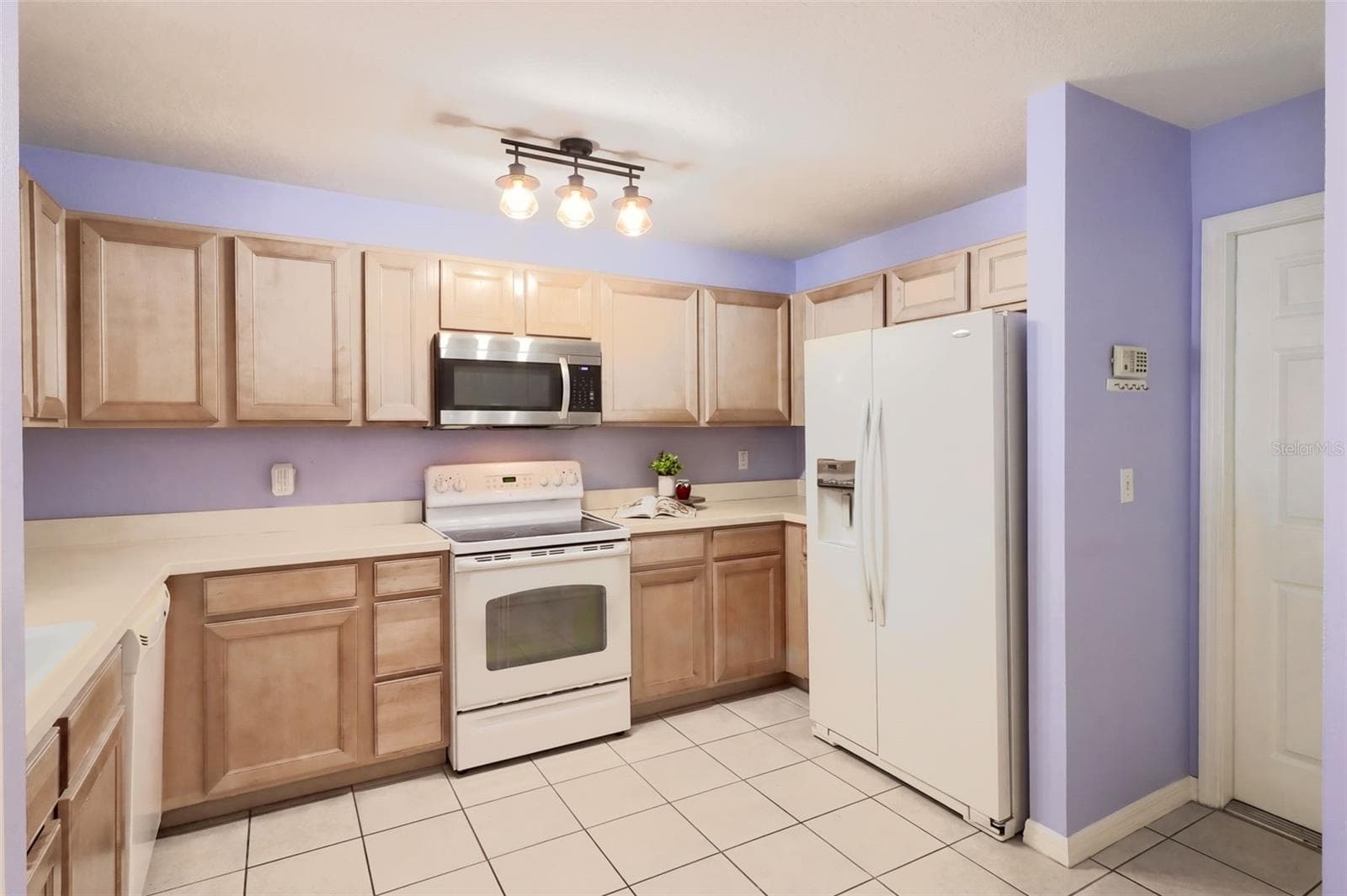 The kitchen features maple wood cabinetry, an updated microwave - 3437 GRENVILLE DR, WINTER HAVEN