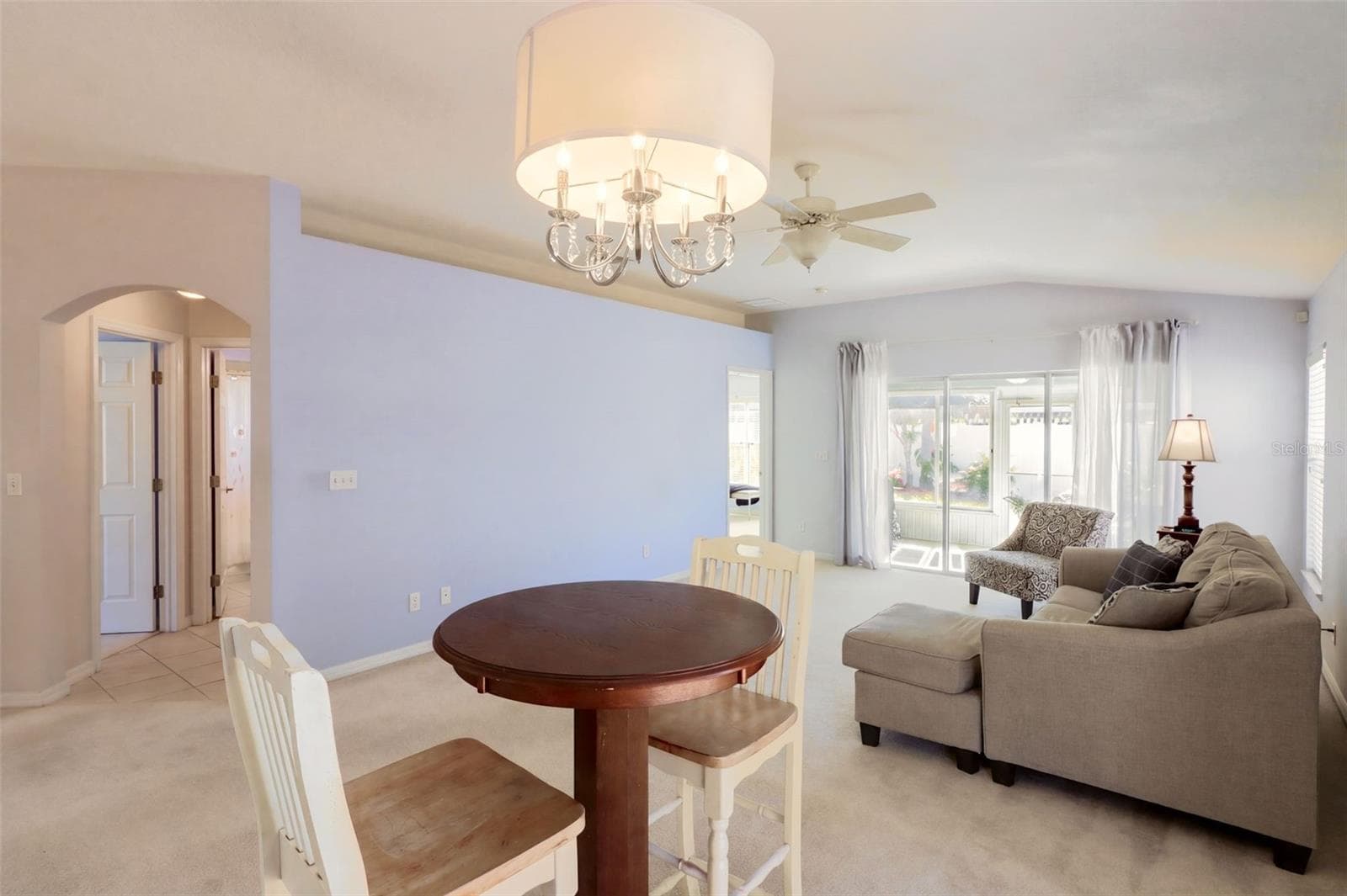 The dining area is highlighted by vaulted ceilings and glass sliding door that leads onto the fenced-in side yard - 3437 GRENVILLE DR, WINTER HAVEN