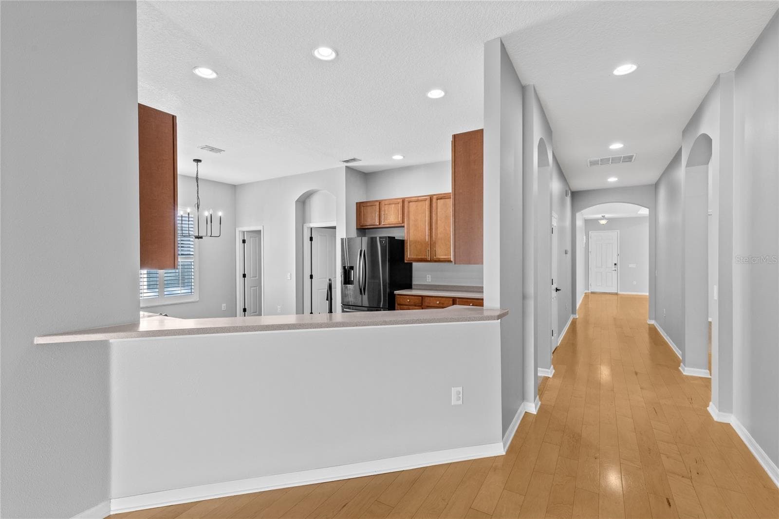 Hallway from front entry and flex room to kitchen - 3214 BAYFLOWER AVE, HARMONY