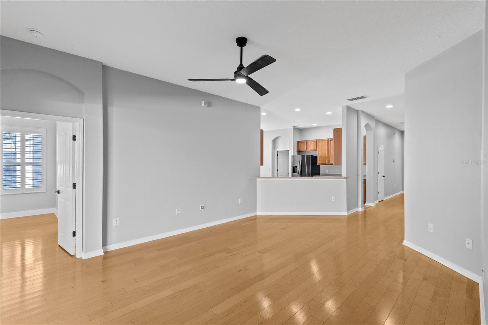Living area off kitchen leading to Primary bedroom - 3214 BAYFLOWER AVE, HARMONY