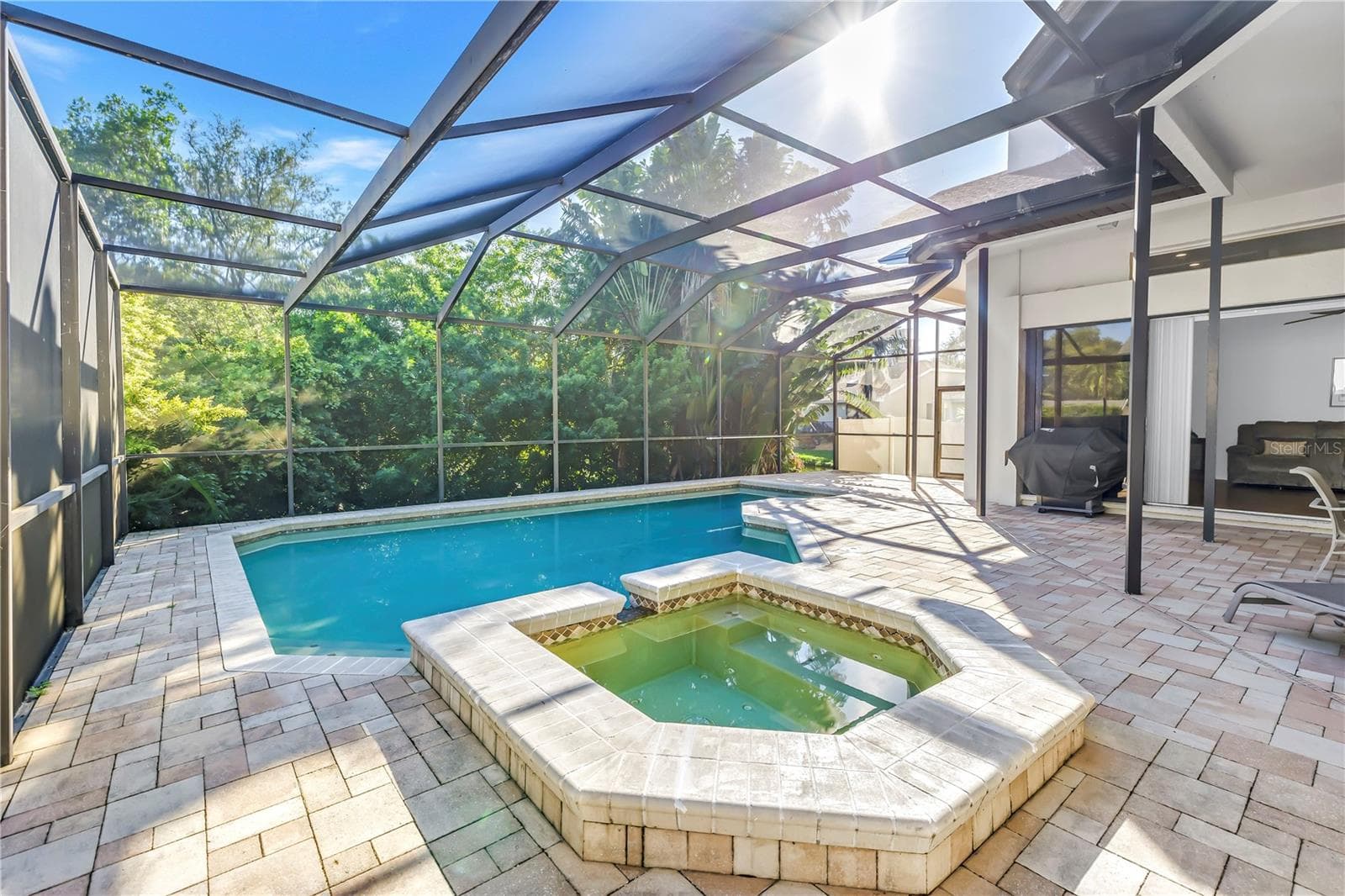 This property features a propane-heated hot tub and a spacious pool, all fully enclosed and protected by a massive screened lanai, creating a true luxury oasis. - 1186 GASPARILLA DR NE, ST PETERSBURG