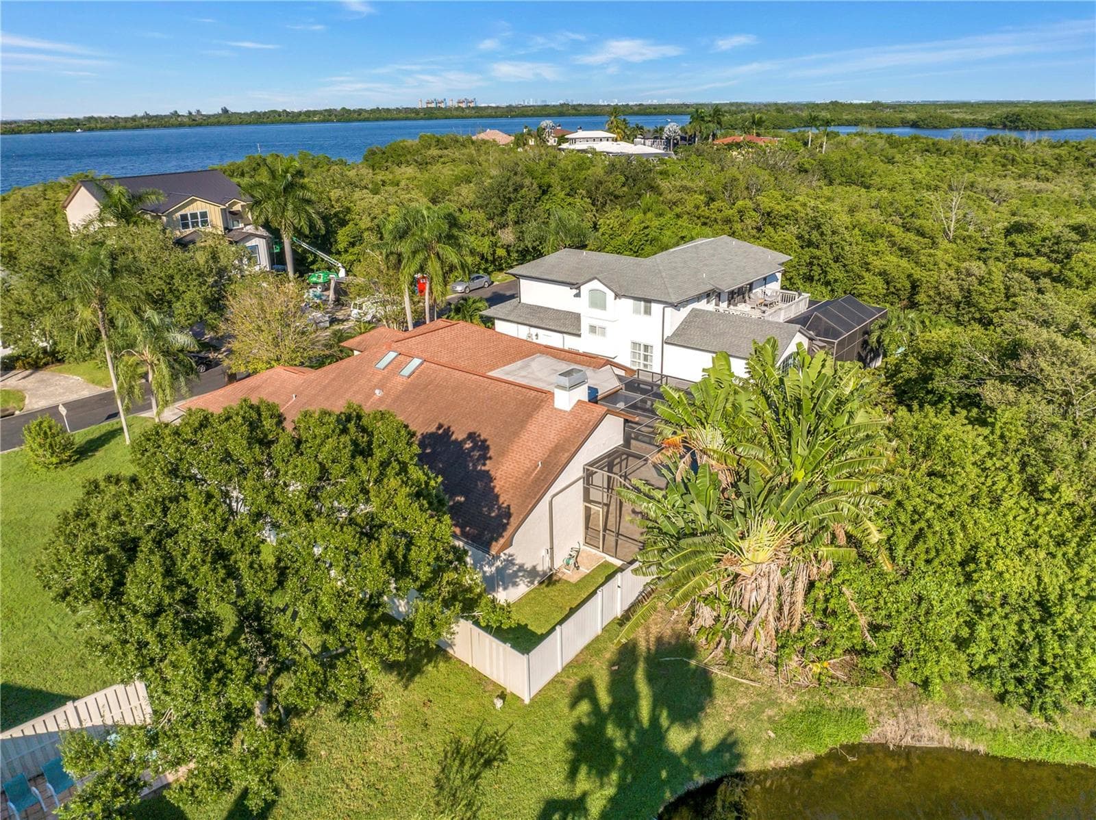 The back corner of the lot features a scenic view of a neighborhood pond, currently enclosed by a private fence. - 1186 GASPARILLA DR NE, ST PETERSBURG