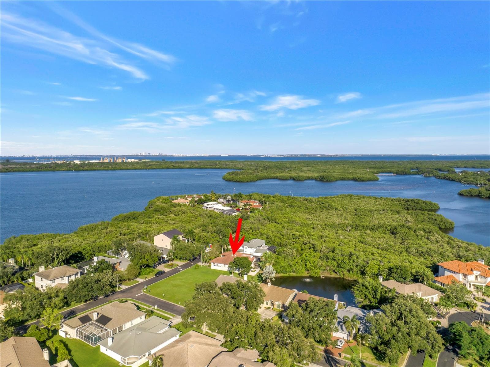 Captures a scenic view of Riviera Bay looking north, with the City of Tampa visible in the distance. This home is ideally situated for easy commuting, offering convenient access to downtown Tampa in approximately 15 minutes. - 1186 GASPARILLA DR NE, ST PETERSBURG
