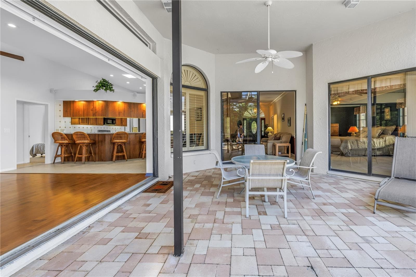This property features 8-foot, 3-panel sliding glass doors that pocket completely to provide seamless transition from the great room to the outdoor pool lanai, perfect for indoor-outdoor living. - 1186 GASPARILLA DR NE, ST PETERSBURG