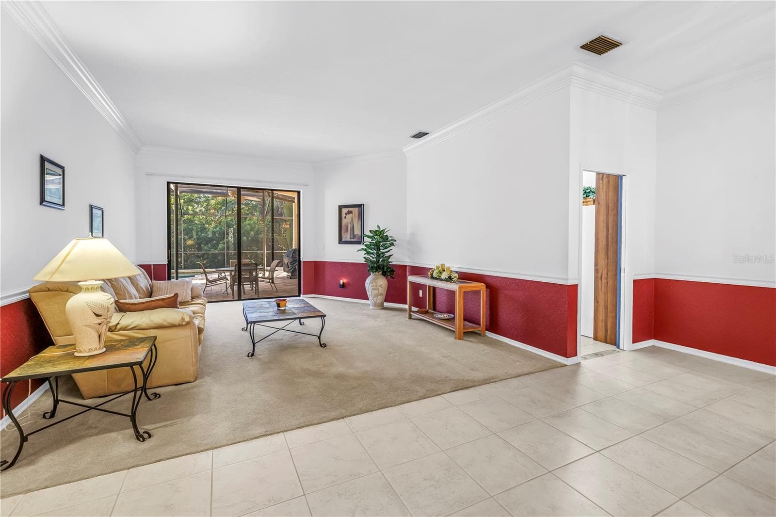 Open concept front room and entry foyer offering an immediate view of the pool oasis through wide 8-ft sliding glass doors set under expansive 10-ft ceilings. SEE VIRTUAL RENDERING IN PHOTO 54 - 1186 GASPARILLA DR NE, ST PETERSBURG