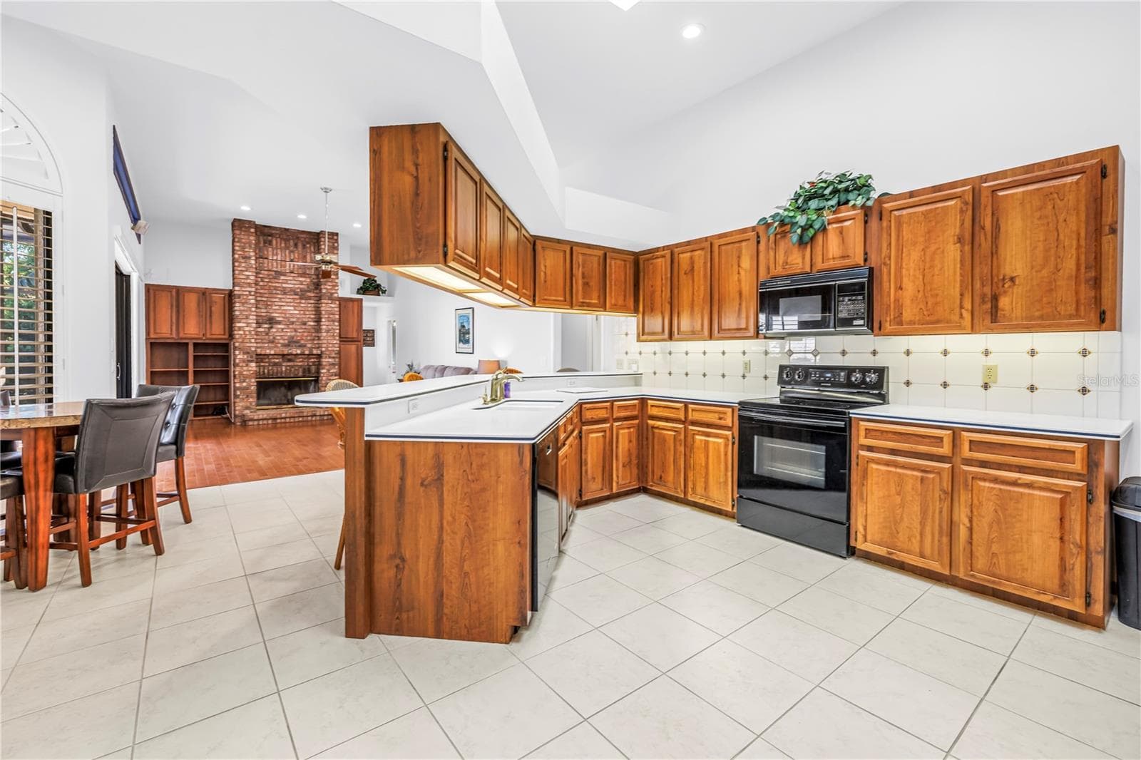 Current photo of kitchen and great room with 12 Ft Ceilings and soffit to secure upper cabinetry - 1186 GASPARILLA DR NE, ST PETERSBURG