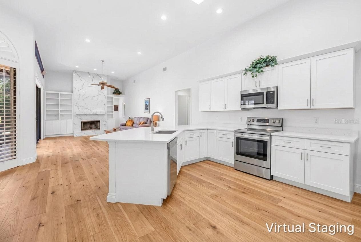 Virtual Rendering of previous photo with updated cabinetry, flooring, fireplace and removal of soffit and hanging upper cabinetry. - 1186 GASPARILLA DR NE, ST PETERSBURG