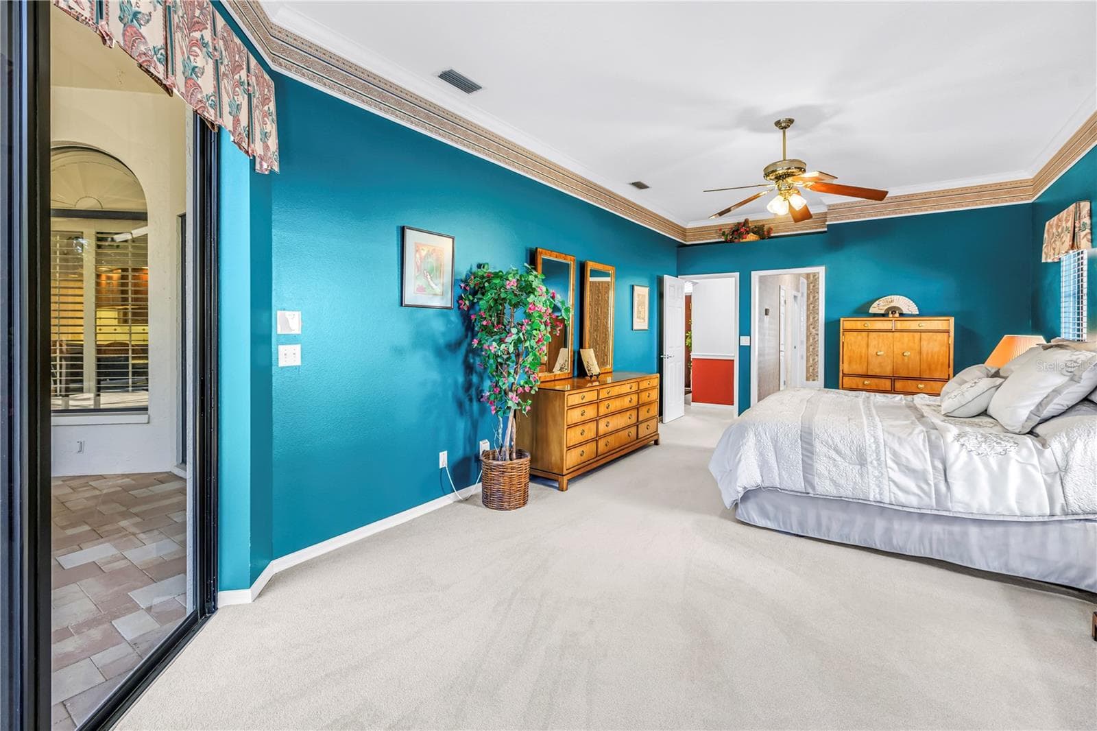 Current Photo of Primary bedroom and doors to the Primary Bath and the Living Space. 10 Foot Ceilings and 8-Ft Sliders to the pool deck - 1186 GASPARILLA DR NE, ST PETERSBURG