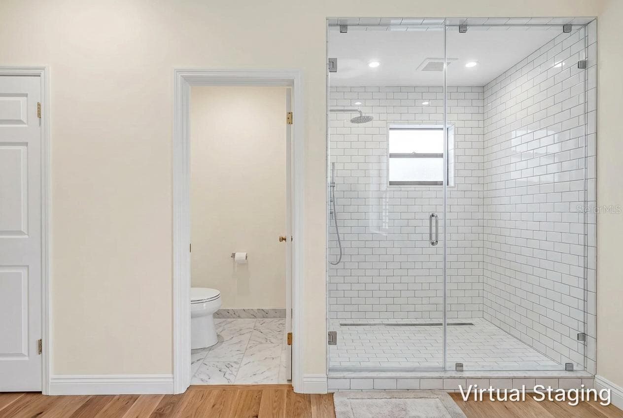 Virtual rendering of new flooring and paint for toilet room and same adjacent shower wall with virtual update to glass walls and tile. - 1186 GASPARILLA DR NE, ST PETERSBURG