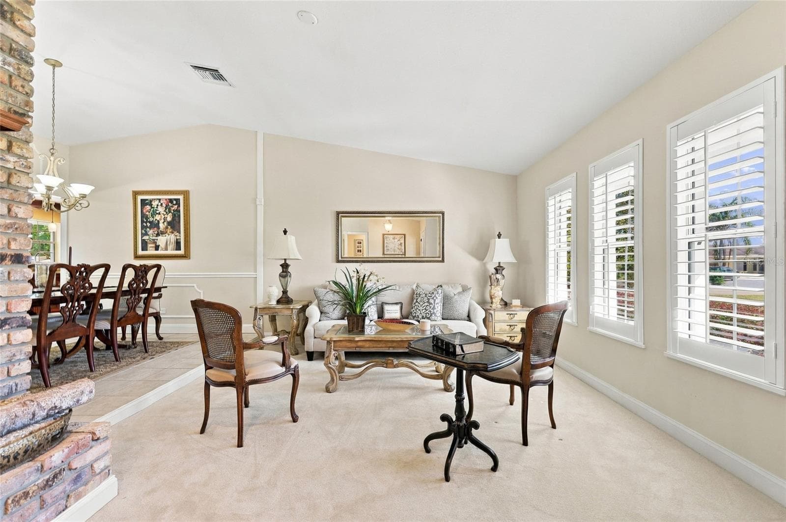 Living Room with plantation shutters & wood burning fireplace - 13205 MARIA AVE, CLERMONT