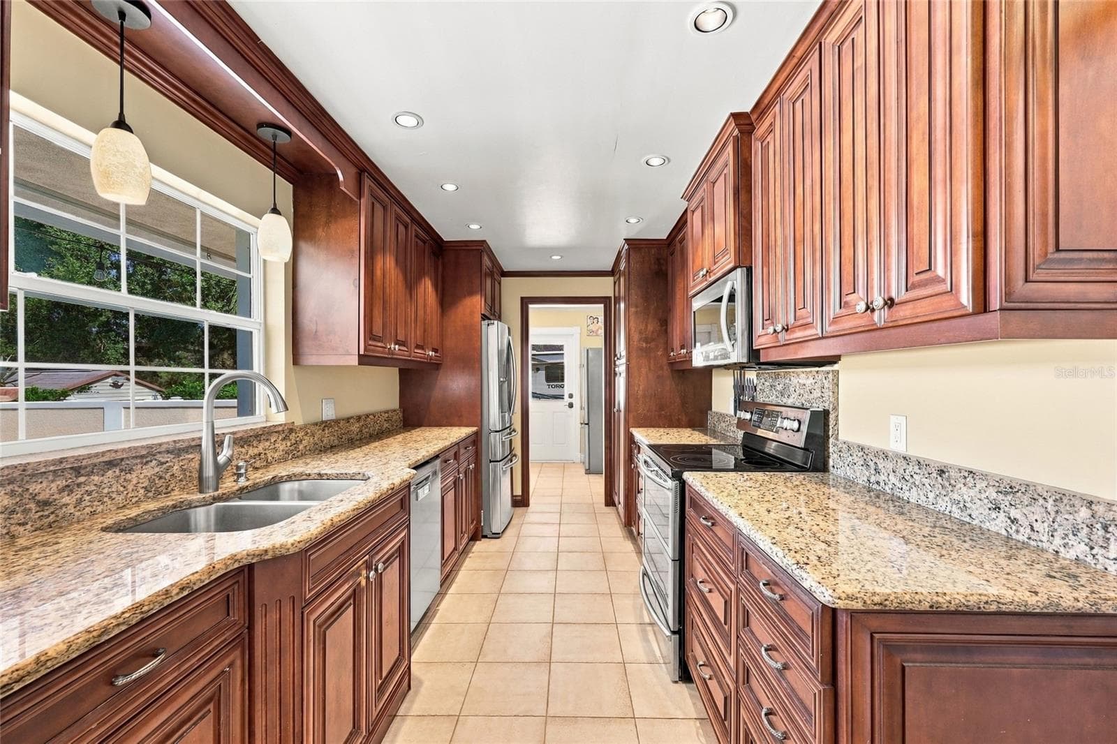 Kitchen with granite counters & view of pool - 13205 MARIA AVE, CLERMONT
