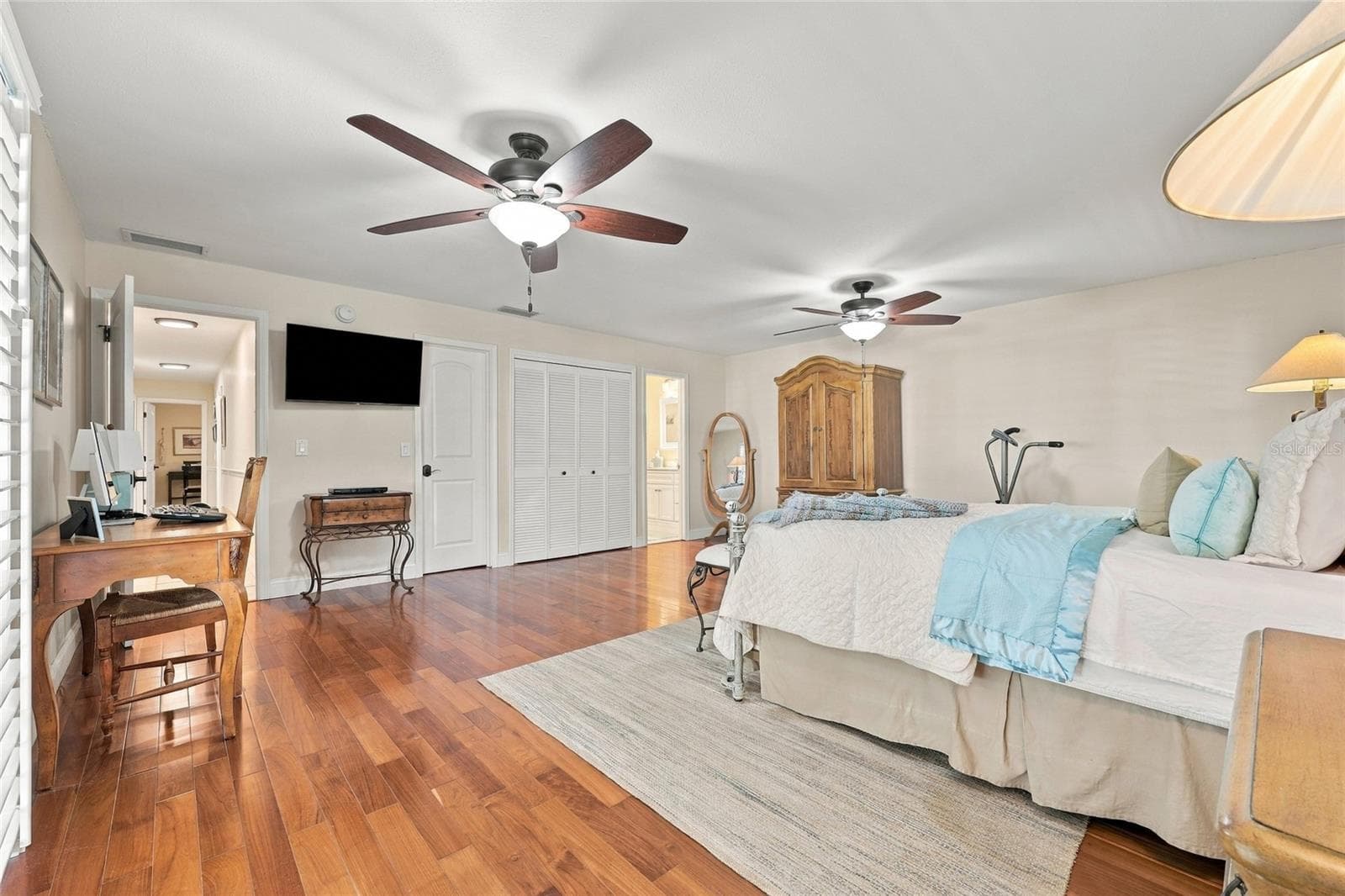 Primary bedroom with teak engineered floors & plantation shutters - 13205 MARIA AVE, CLERMONT