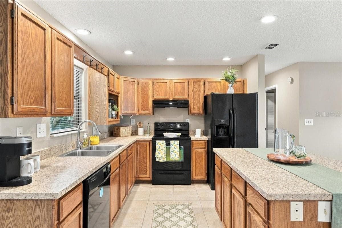 Kitchen features new counter tops, appliances convey and large kitchen island for good workspace. - 5244 QUIET CREEK LN, LAKELAND