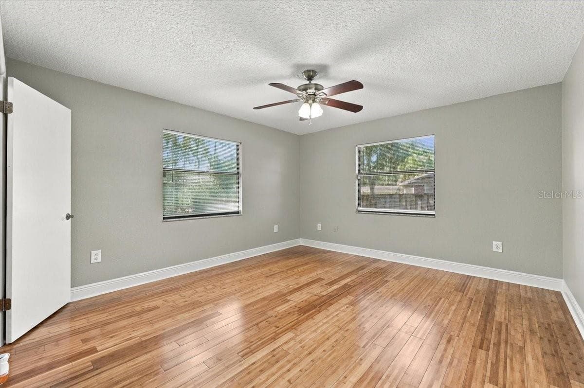 Primary bedroom is split from the other bedrooms, ceiling fan, walk in closet, new blinds and bamboo hardwood flooring. - 5244 QUIET CREEK LN, LAKELAND