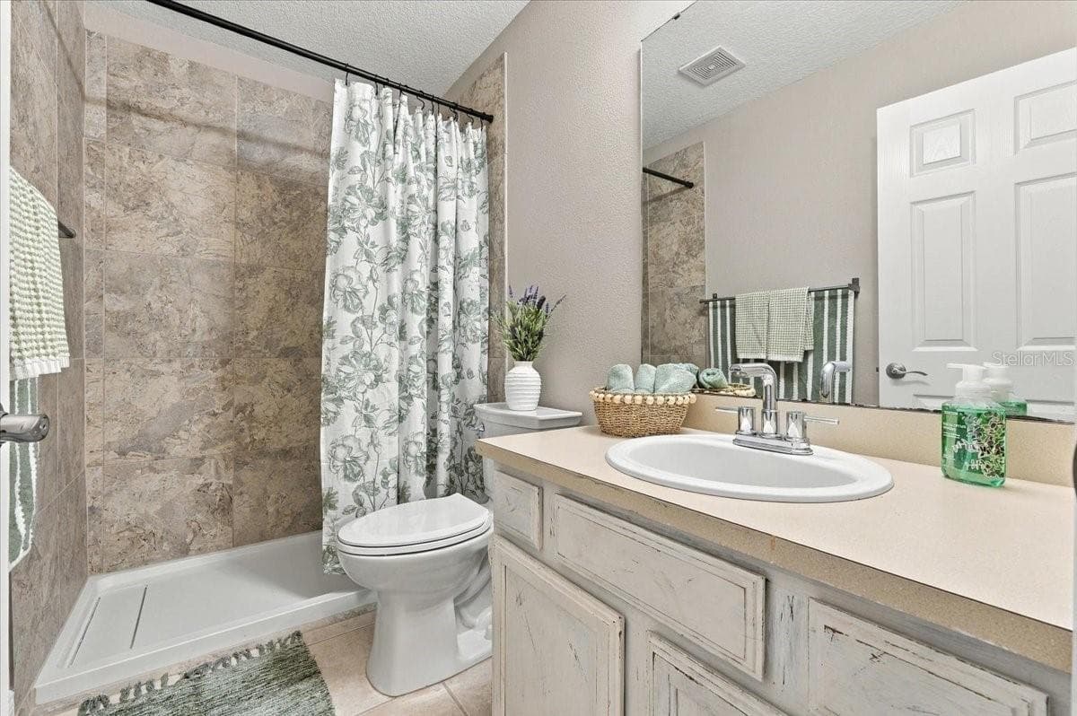 Guest bath with updated shower, new toilet ceramic tile flooring. - 5244 QUIET CREEK LN, LAKELAND