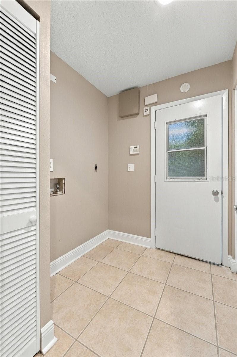 Inside utility room with access to the garage. Electric washer and dryer hook ups. - 5244 QUIET CREEK LN, LAKELAND