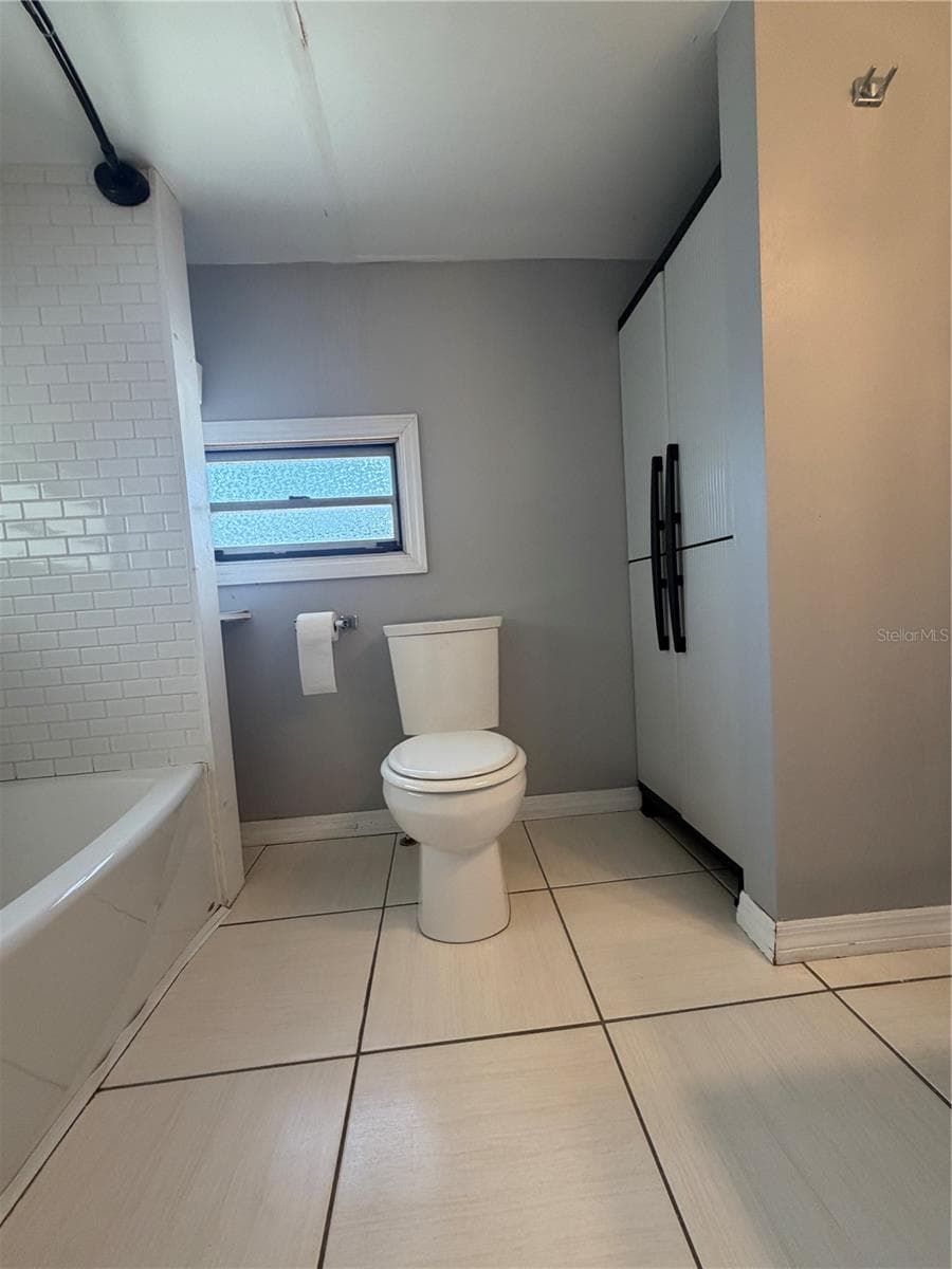 Bathroom with view of storage, tub/shower. - 4120 BUENA VISTA LN, HOLIDAY