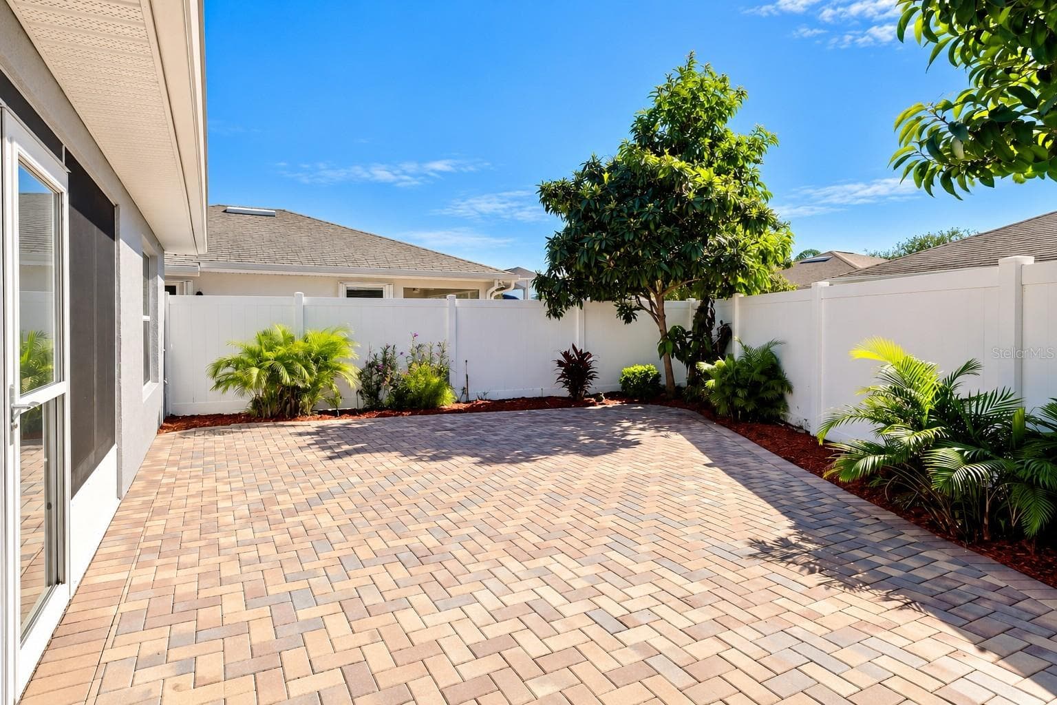 Low-maintenance courtyard, enhanced with pavers and Florida-friendly landscaping, provides a private and inviting outdoor retreat. - 3437 GRENVILLE DR, WINTER HAVEN