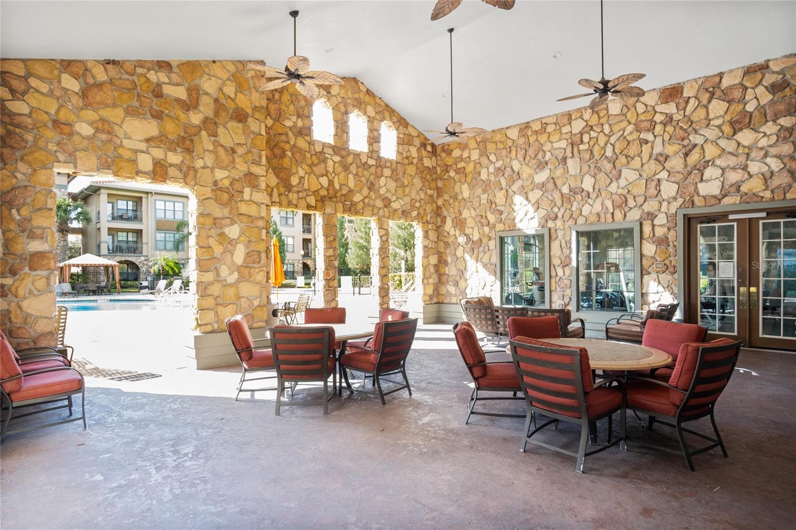 Covered seating by the large community pool - 912 CHARO PKWY #232, DAVENPORT