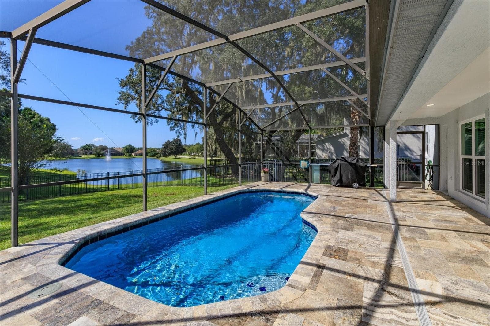 Freshly sealed Travertine pavers surround the screen enclosed pool - 6887 HIDDEN GLADE PL, SANFORD