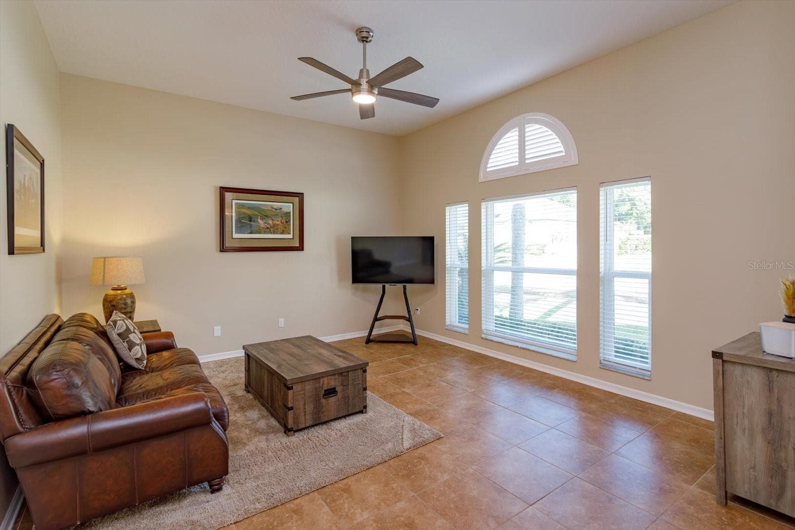 Freshly painted living room with new windows and new ceiling fan - 6887 HIDDEN GLADE PL, SANFORD
