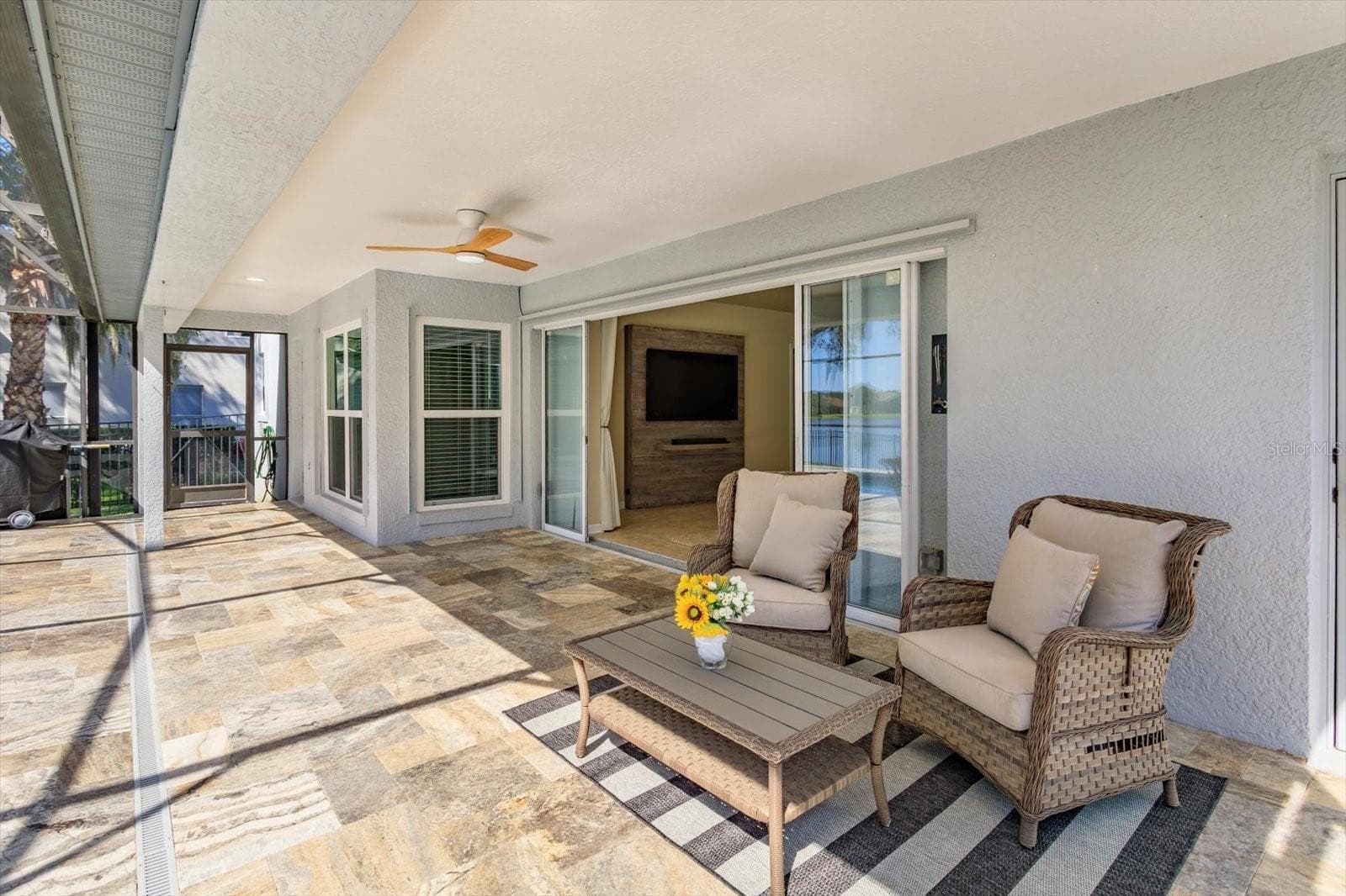 Travertine covered porch with double pocket sliding doors - 6887 HIDDEN GLADE PL, SANFORD