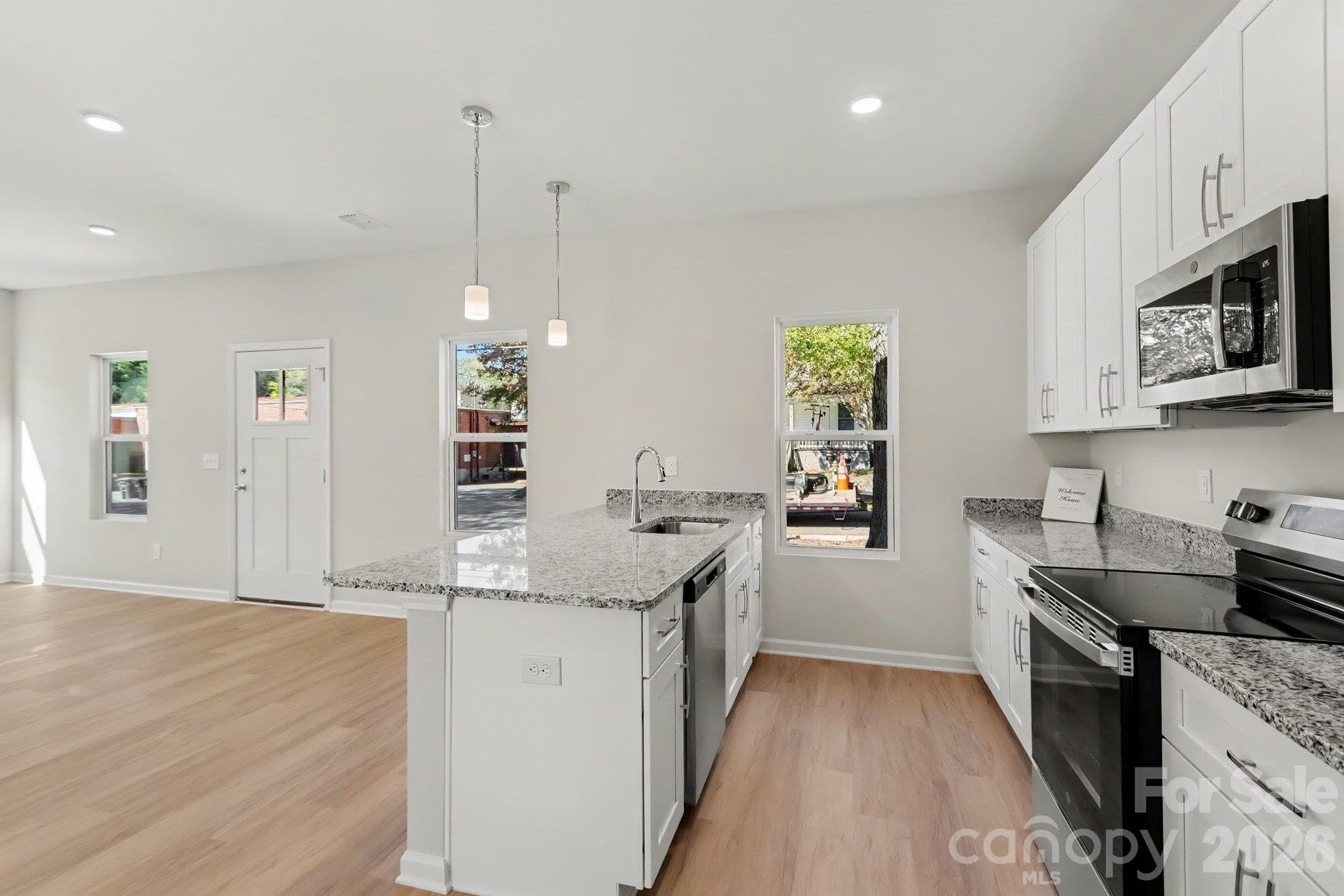 Kitchen features stainless steel farm style sink with granite island, disposal, dishwasher, electric range and microwave. Pendant lighting and recessed lighting offers a modern feel and soft close drawers and cabinet doors add to the list of features. - 125 Buffalo Avenue NW, Concord