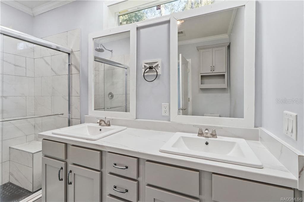 A BEAUTIFULLY FINISHED PRIMARY BATH! Enjoy a DOUBLE-SINK VANITY w/GRAY CABINETRY, marble-look countertops, framed mirrors & a spacious WALK-IN SHOWER. - 7528 N CHABAUD TER, CRYSTAL RIVER