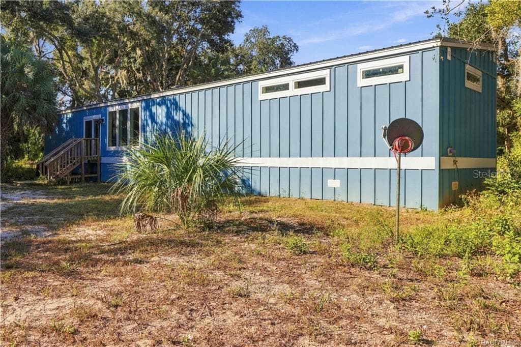 A LITTLE BIT COUNTRY, A LOT TO LOVE! The home's attractive BLUE EXTERIOR, WHITE TRIM & METAL ROOF complement the surrounding natural Florida landscape. - 7528 N CHABAUD TER, CRYSTAL RIVER