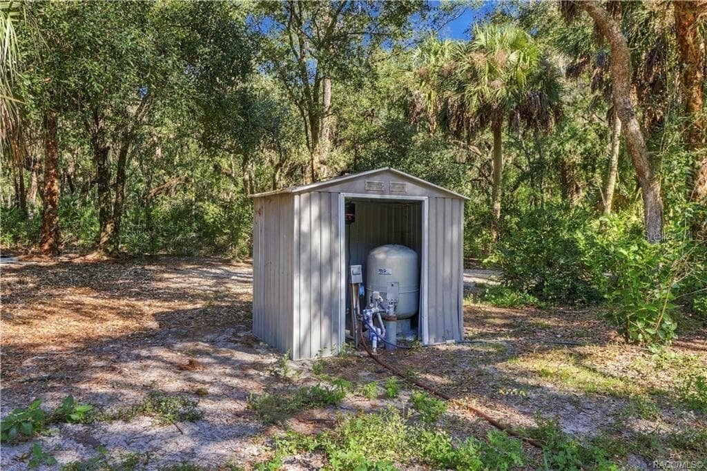 A PRACTICAL PROPERTY FEATURE! A separate enclosure houses the property's well equipment, surrounded by mature trees & natural vegetation. - 7528 N CHABAUD TER, CRYSTAL RIVER