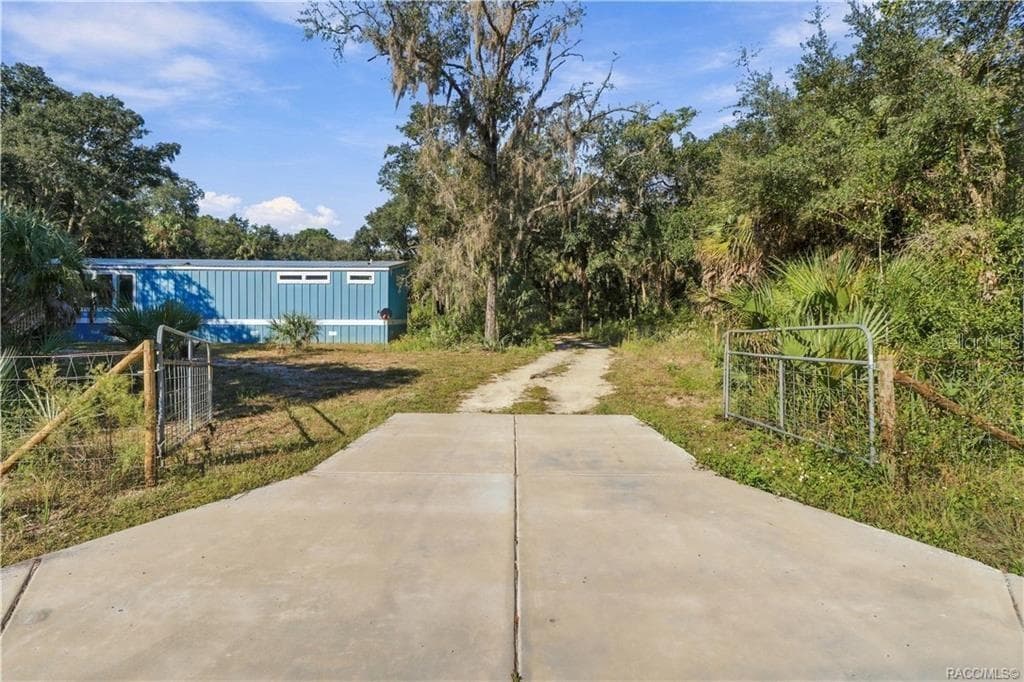 A GATED ENTRANCE WELCOMES YOU! The concrete driveway apron leads through a gated entrance into the 1.42 FULLY FENCED ACRES, offering space for vehicles & outdoor toys. - 7528 N CHABAUD TER, CRYSTAL RIVER