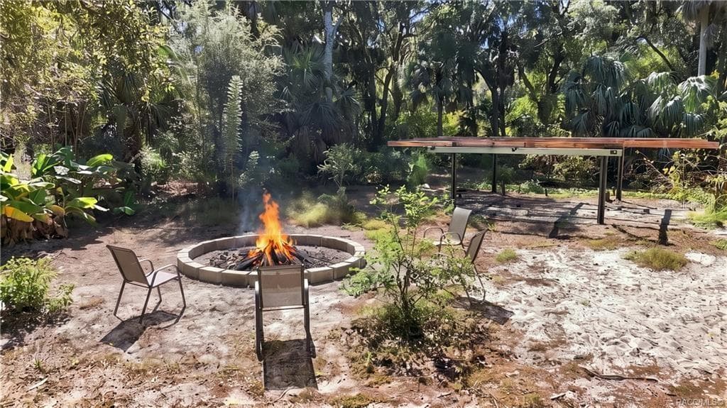 GATHER AROUND THE FIRE! A circular FIRE PIT AREA surrounded by seating offers an inviting spot for evening conversations, roasting marshmallows & enjoying the outdoors. - 7528 N CHABAUD TER, CRYSTAL RIVER