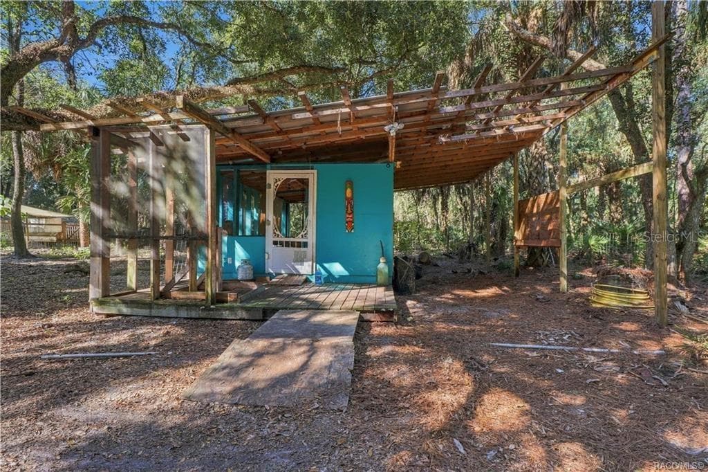 A UNIQUE OUTDOOR SPACE! A closer view of the rustic structure showcases its wooden deck, screened section & extended overhead framework. - 7528 N CHABAUD TER, CRYSTAL RIVER