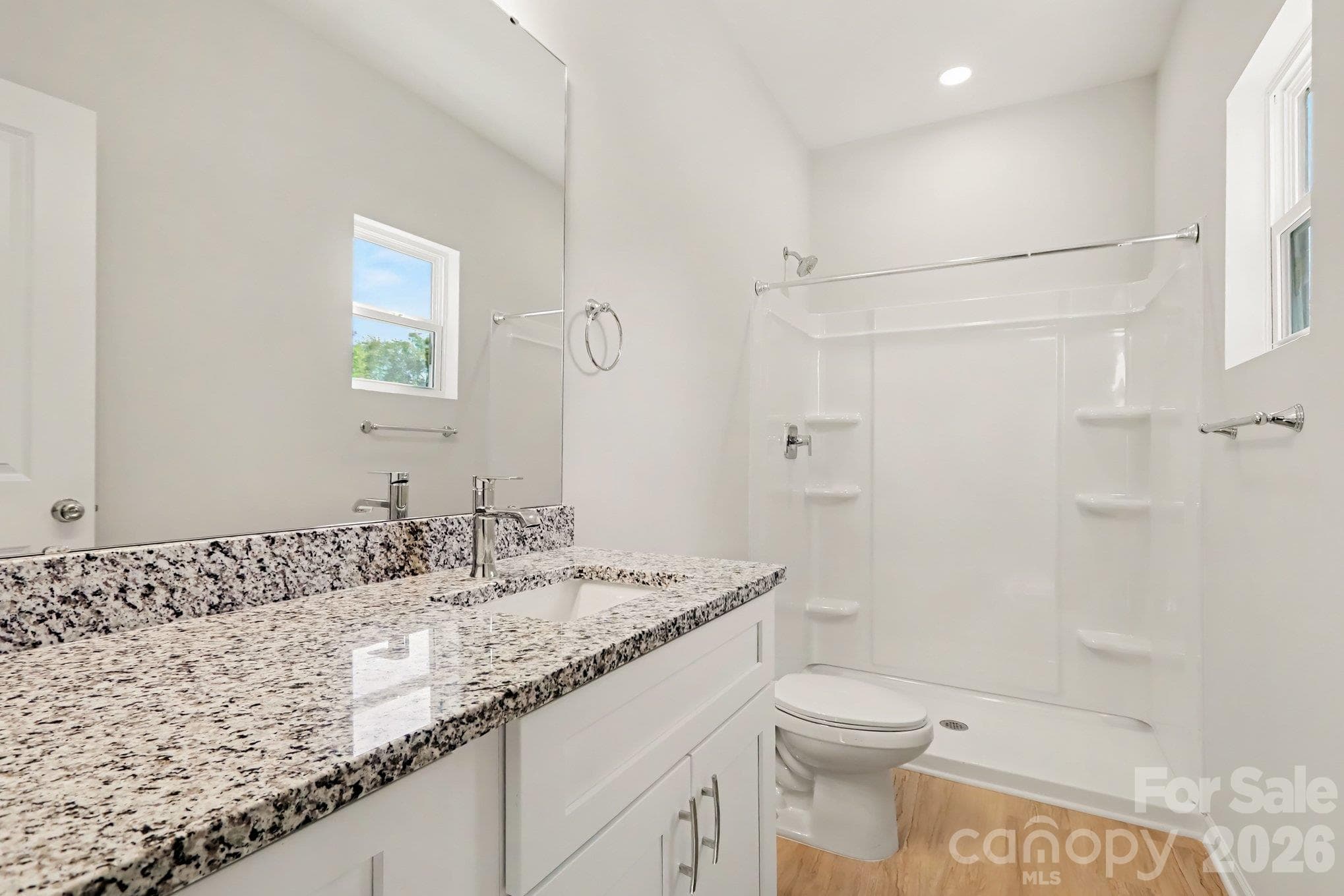 Primary ensuite bathroom with single vanity with granite countertop and a walk in shower. Actual non-staged photo. - 125 Buffalo Avenue NW, Concord