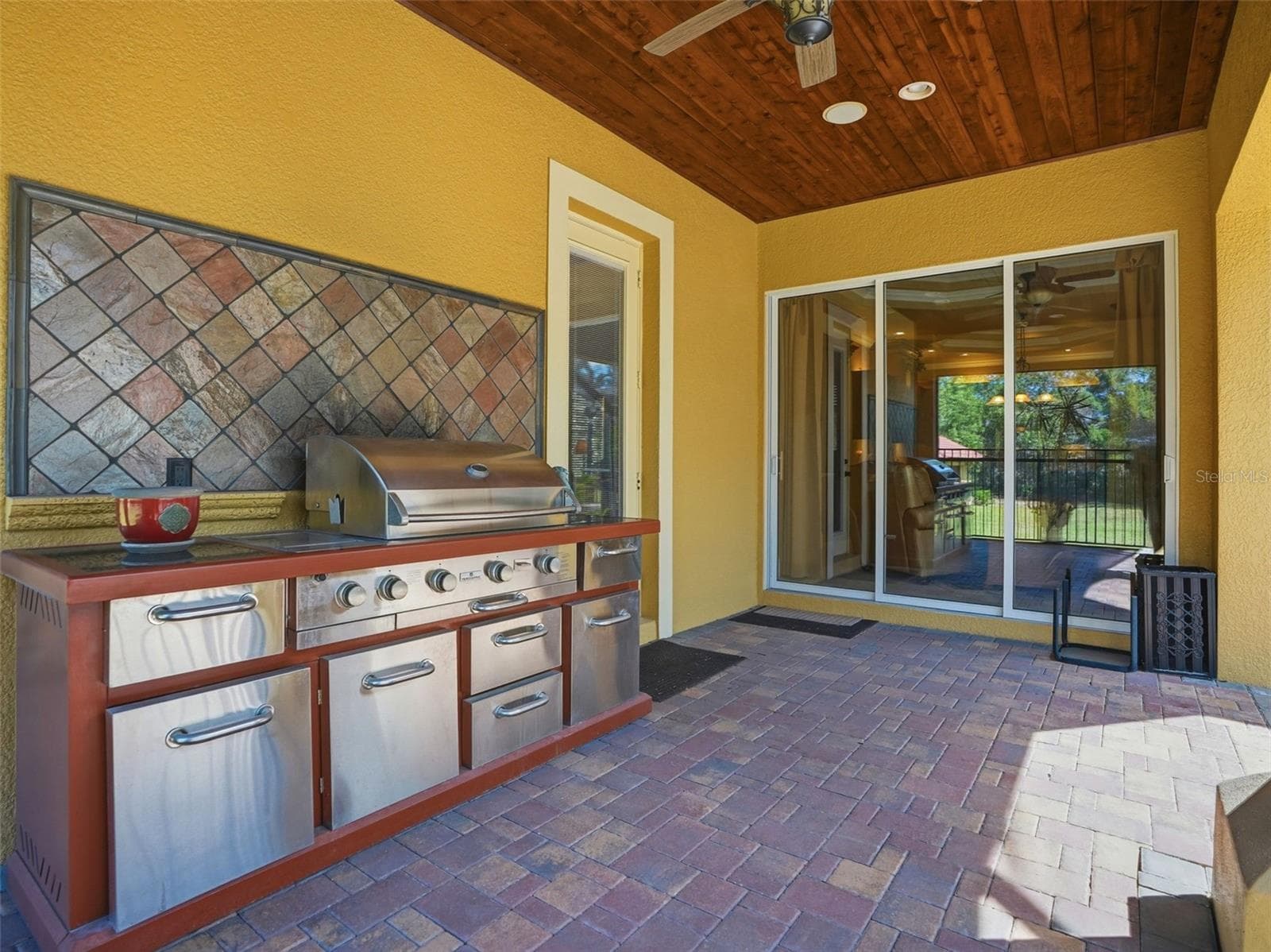 Outdoor kitchen with propane grill and seating area overlooking the pool. Easy access to the kitchen. - 9313 HERNANDO RIDGE RD, WEEKI WACHEE