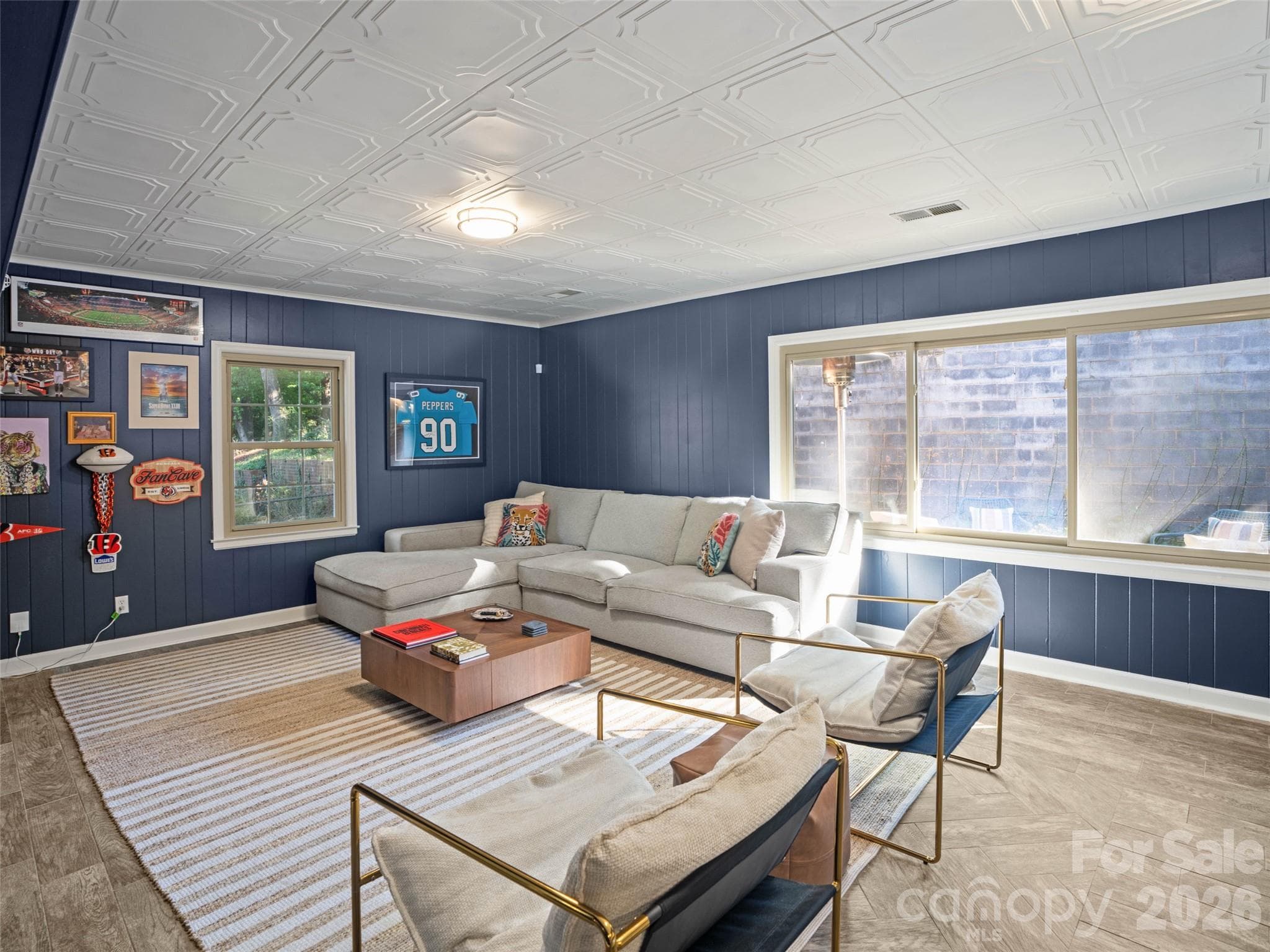 This expansive second living area in the basement offers a beautiful blend of style and functionality. Gorgeous tile flooring, decorative ceiling tiles, and fresh paint create a polished, updated look, while large windows flood the space with natural light and provides so much room to spread out, relax, and entertain. - 6626 Rocky Falls Road, Charlotte