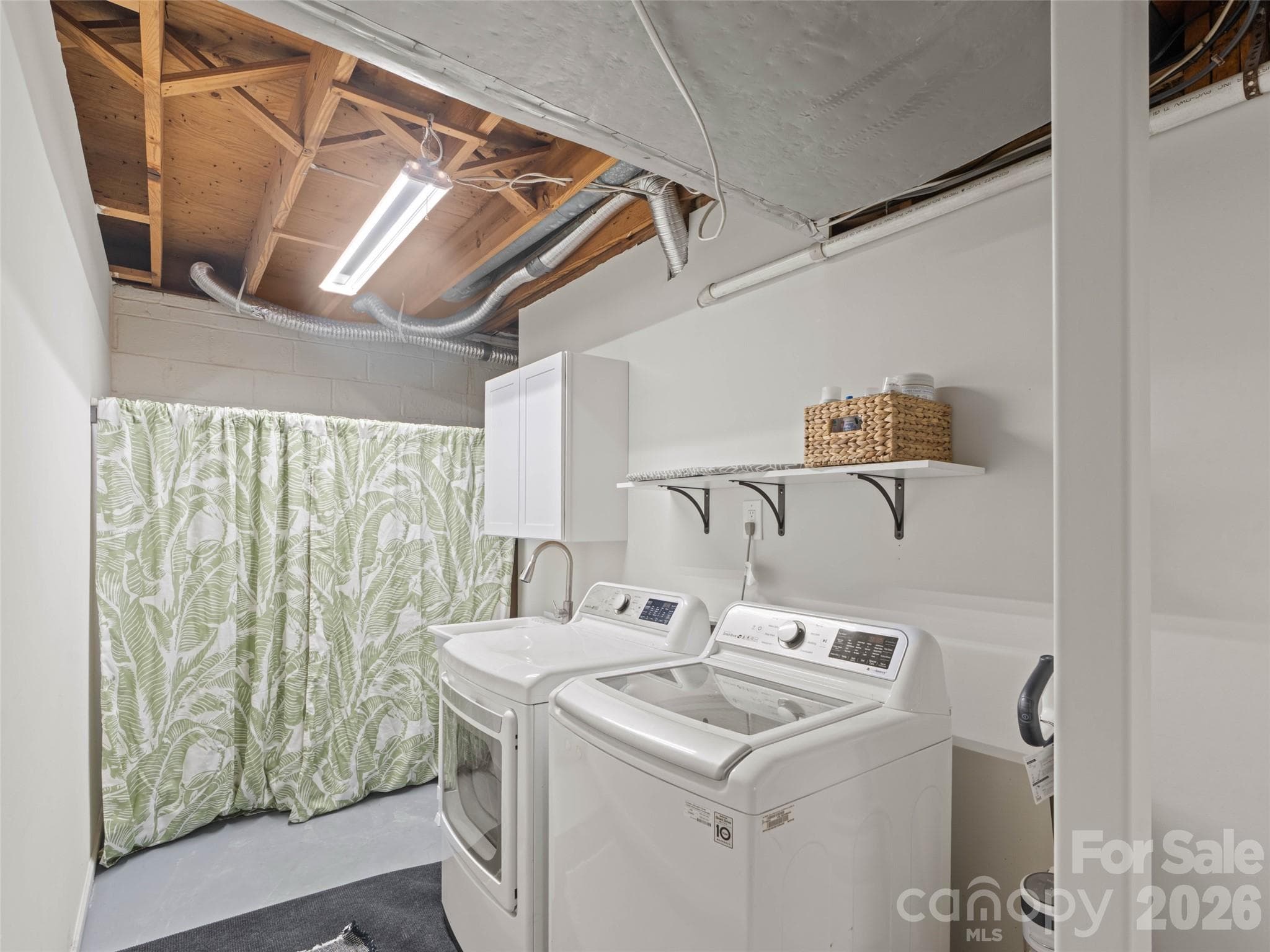 The spacious basement laundry area offers plenty of room to create the laundry room of your dreams! Featuring a convenient wash sink and abundant space for additional storage, this functional area provides endless possibilities for organizing, folding, and tackling laundry with ease. - 6626 Rocky Falls Road, Charlotte