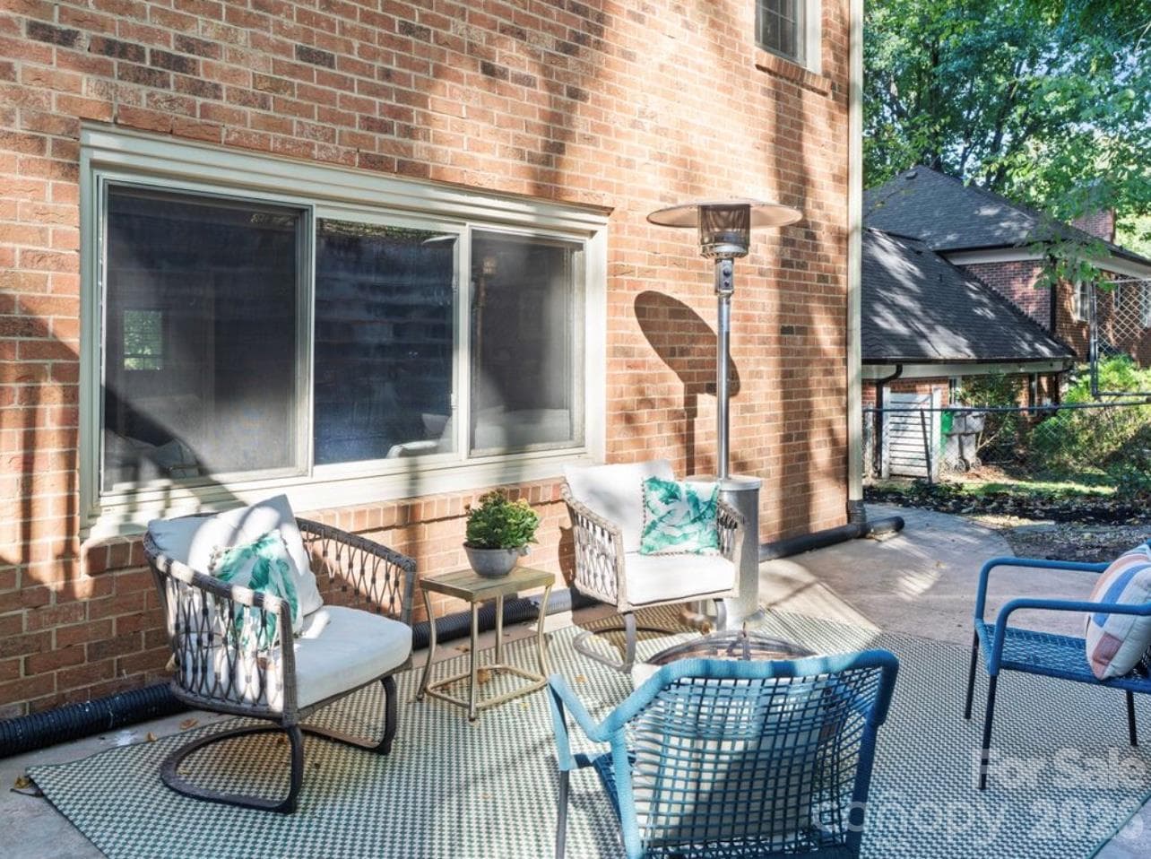 Natural light pours through the expansive windows overlooking the patio, creating a bright and welcoming atmosphere in the basement’s second living area. - 6626 Rocky Falls Road, Charlotte