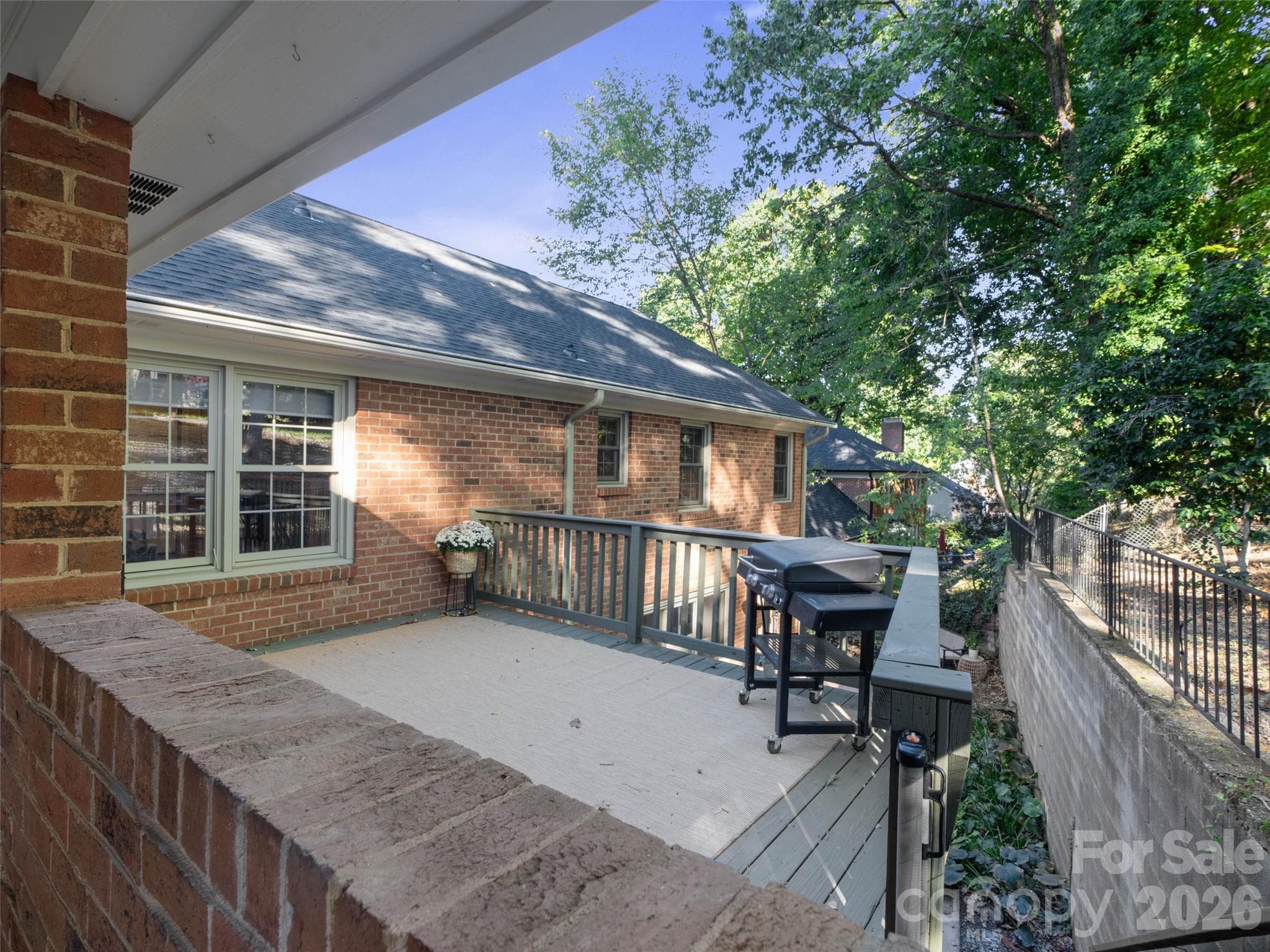 A spacious deck offers convenient access from the carport and direct access to the backyard, overlooking the patio below. This versatile outdoor space is perfect for relaxing, entertaining, and enjoying the surrounding outdoor areas. - 6626 Rocky Falls Road, Charlotte