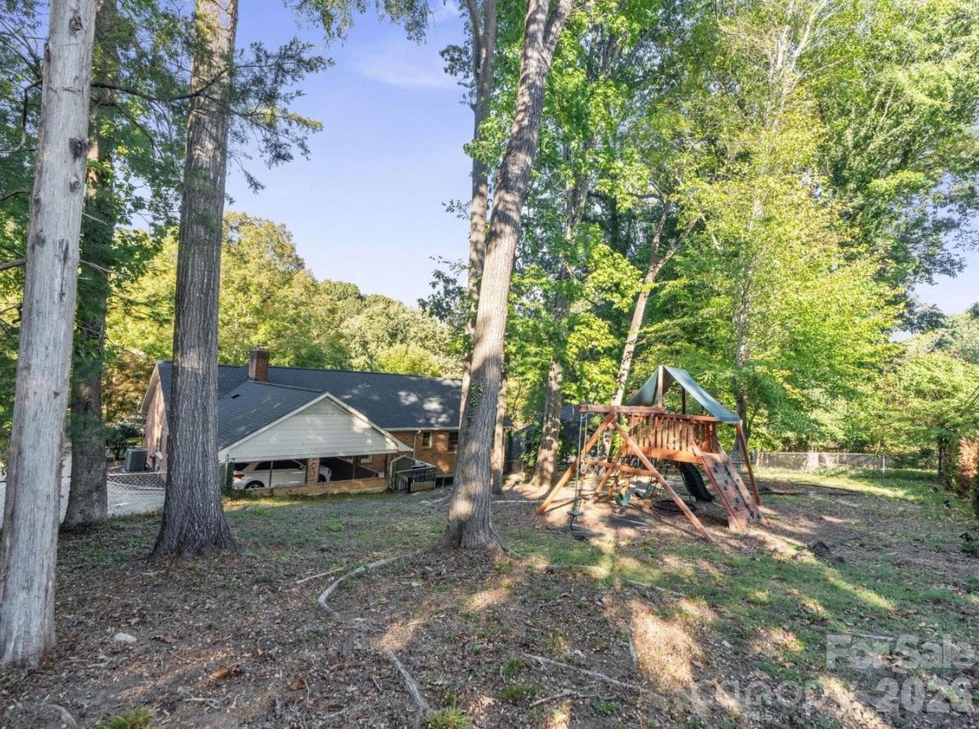 A view of the property from the back corner of the yard showcases the fenced backyard and outdoor space surrounding the home. With room to personalize and create your own backyard oasis, this outdoor area offers wonderful potential for relaxing, gardening, entertaining, and enjoying time outdoors. - 6626 Rocky Falls Road, Charlotte