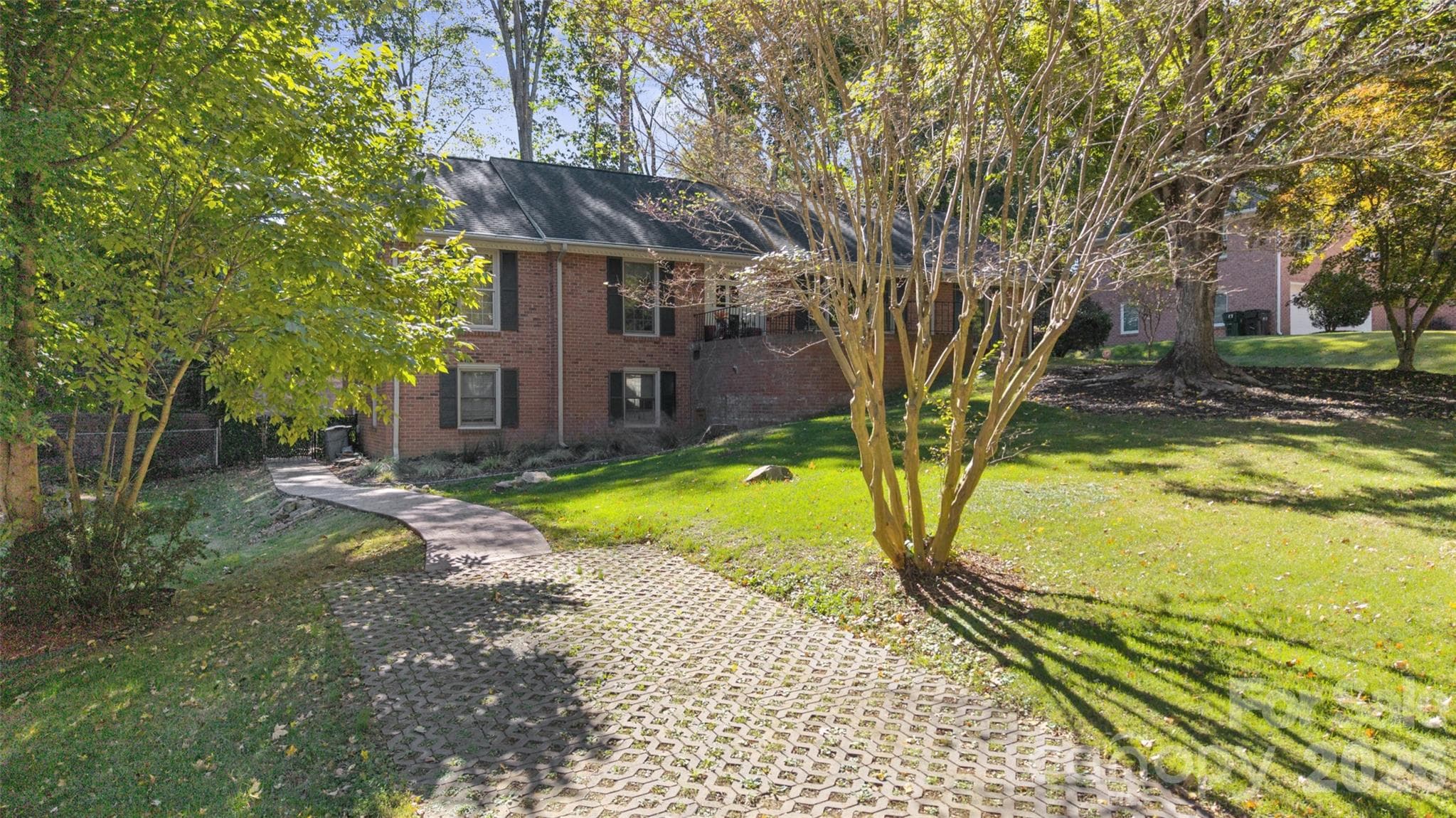 This view highlights the convenience of the basement’s separate access, featuring its own dedicated parking pad and sidewalk leading directly to the rear entrance. - 6626 Rocky Falls Road, Charlotte