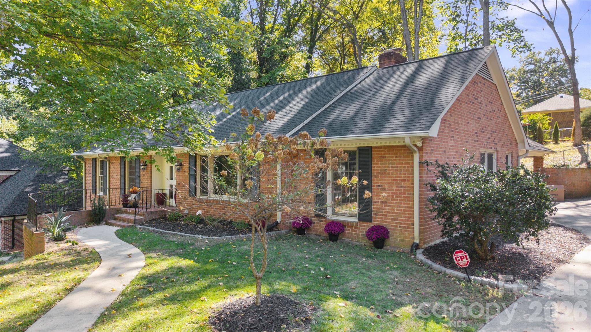 Front and side view showcasing the  front sidewalk and access to the carport at the back of the property. - 6626 Rocky Falls Road, Charlotte