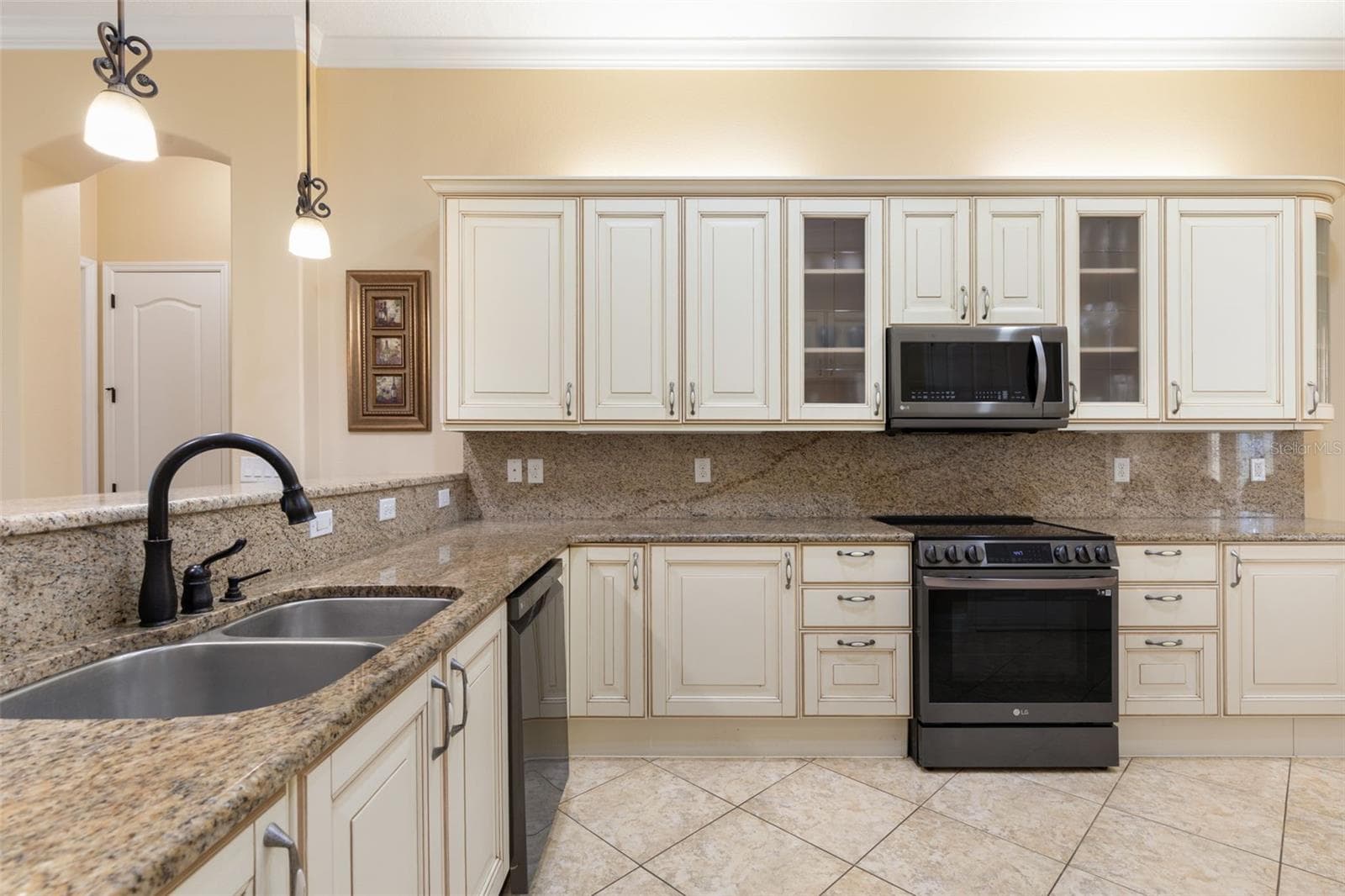Italian-inspired cabinetry, granite countertops and matching backsplash bring timeless elegance to this beautifully designed kitchen. - 25 EMERALD LAKE CT, PALM COAST