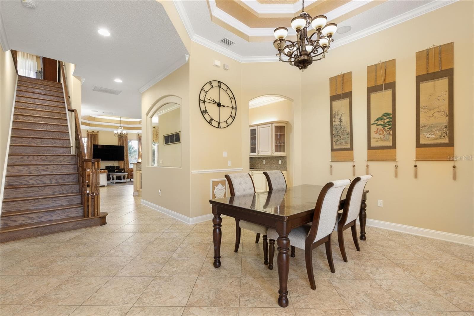 A beautifully appointed dining room with an elegant tray ceiling, decorative chandelier and architectural details that create a memorable setting for gatherings. - 25 EMERALD LAKE CT, PALM COAST