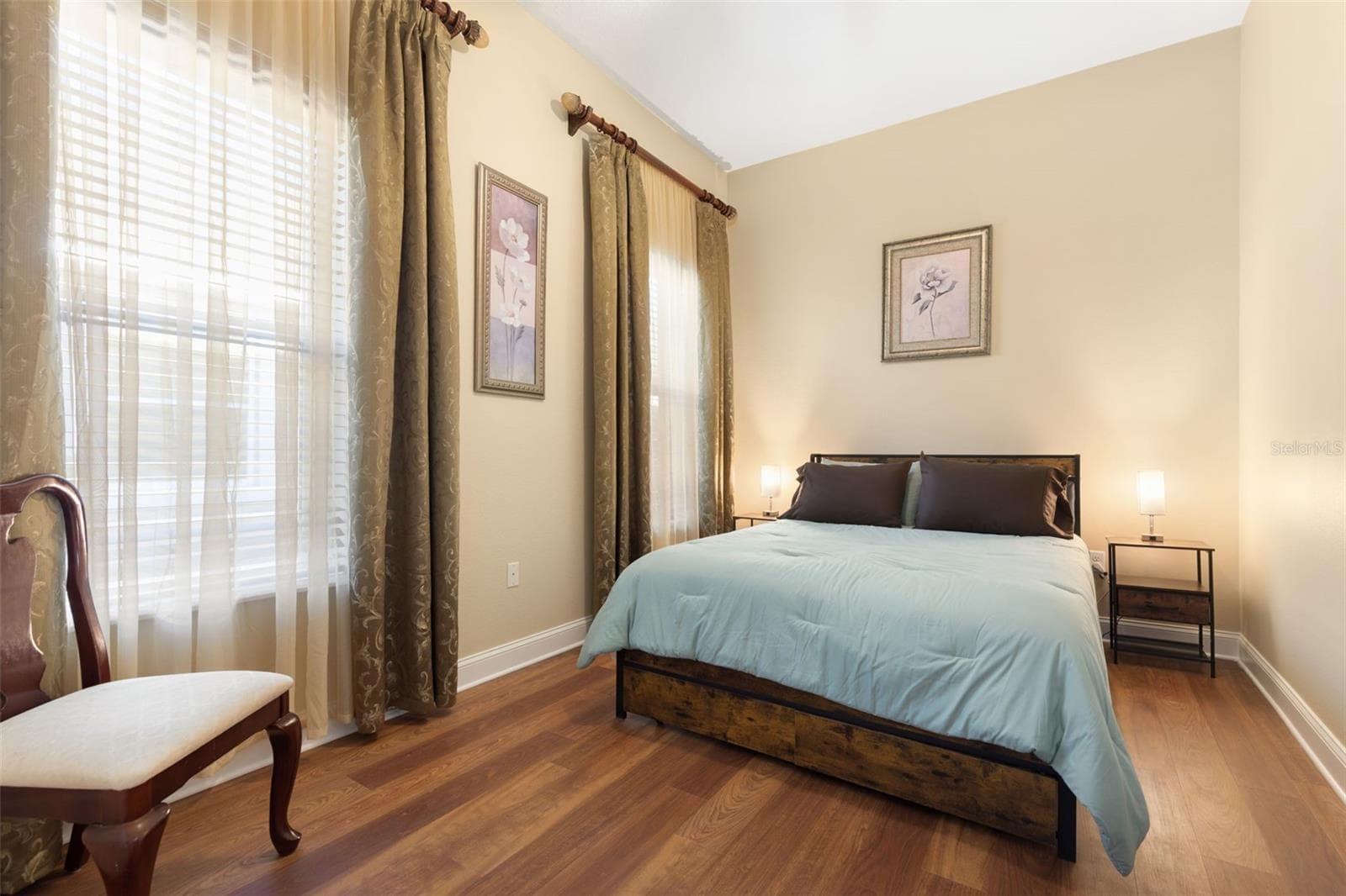 First-Floor Bedroom #2 offers a tranquil, comfortable retreat with warm wood-look flooring and a peaceful atmosphere. - 25 EMERALD LAKE CT, PALM COAST